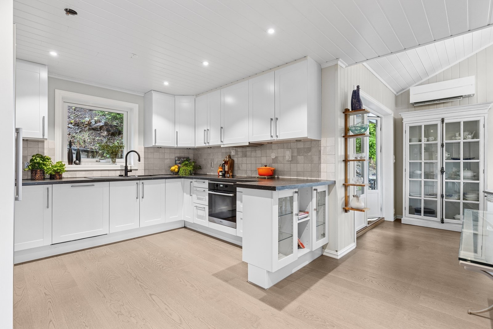 Stort og innholdsrikt kjøkken i delvis åpen løsning. Galleribilde