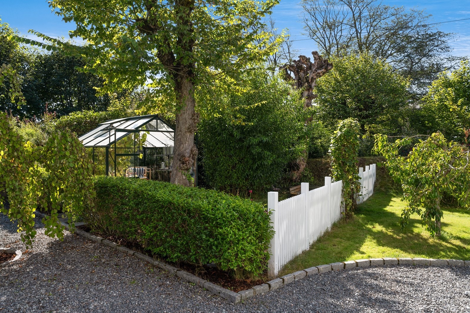 Opparbeidet tomt med ulike beplantninger, bedd og trær Galleribilde