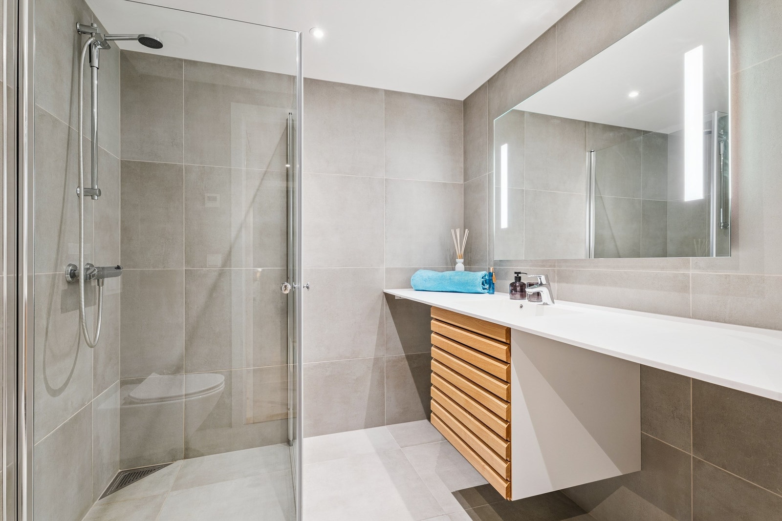 Her er det en romslig dusjnisje med glassvegger og praktisk opplegg for vaskemaskin. Galleribilde