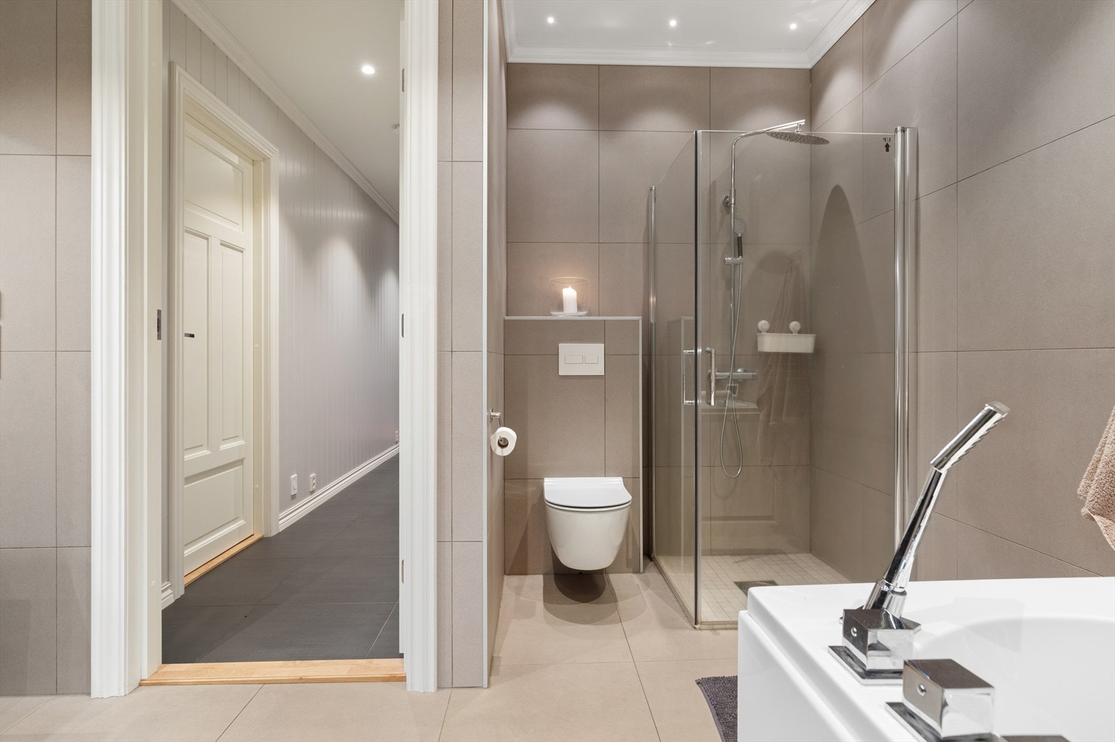 Badet er innredet med massasjekar, dusjhjørne, vegghengt toalett og romslig innredning med dobbelservant. Galleribilde