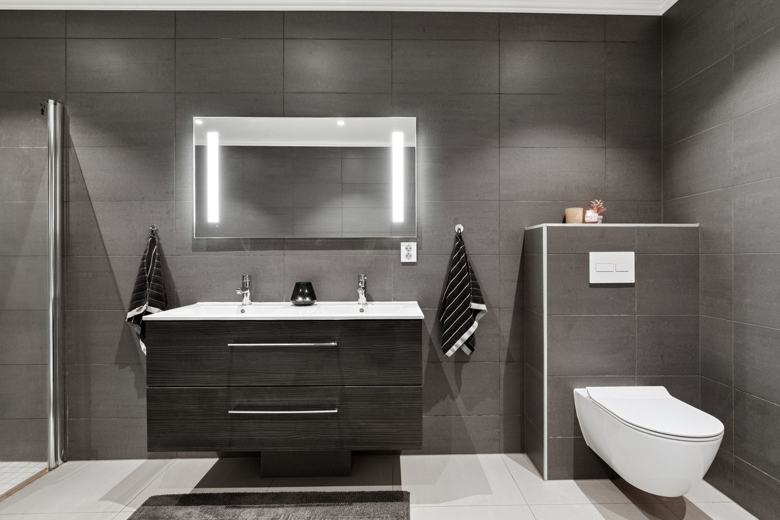 Badet nede er innredet med vegghengt toalett, dusjhjørne, innredning med dobbelservant og massasjekar. Galleribilde