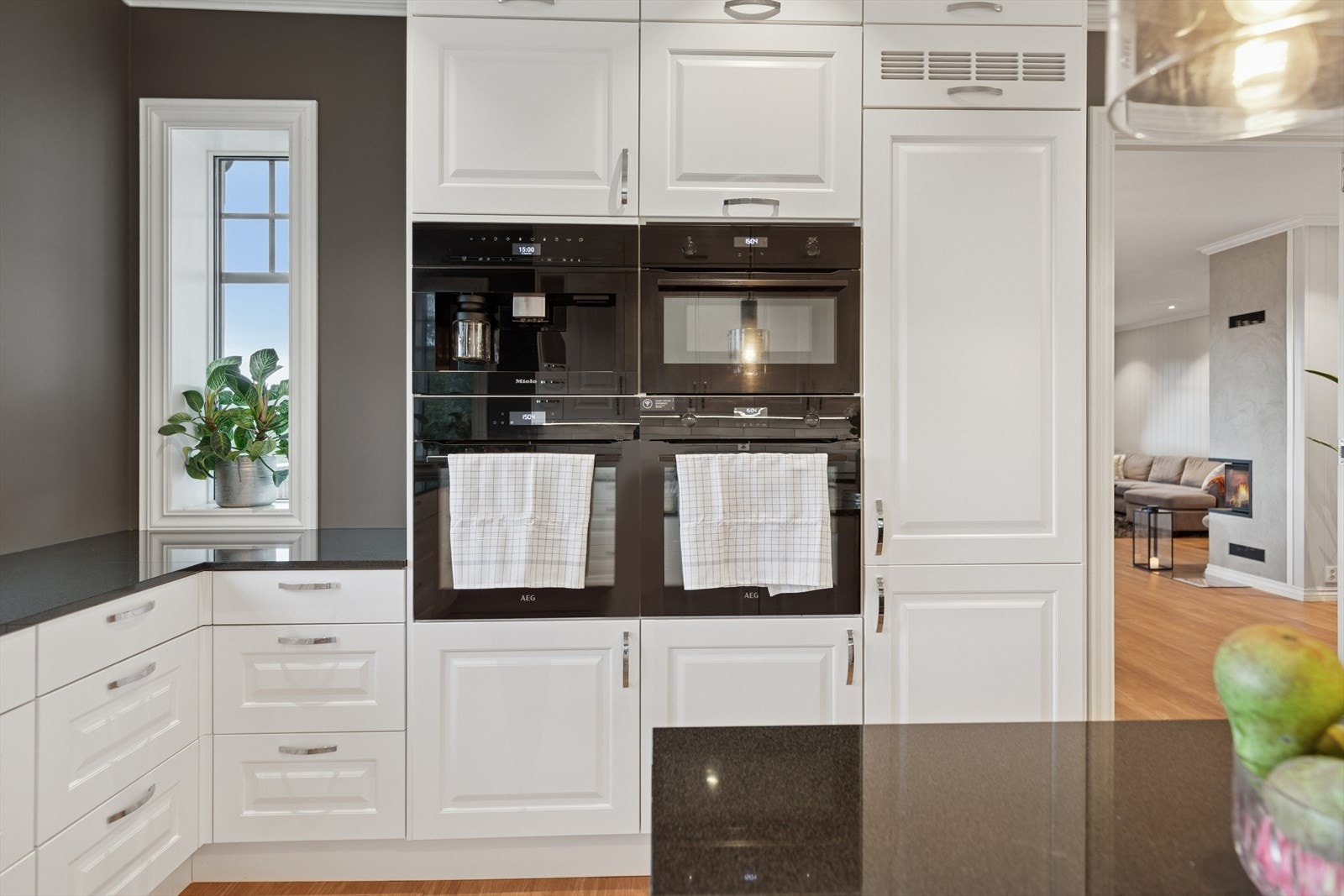 Svært innholdsrikt kjøkken med integrete hvitevarer bestående av to komfyrer, mikrobølgeovn, kaffemaskin, vinskap, oppvaskmaskin og frys/kjøleskap. Galleribilde