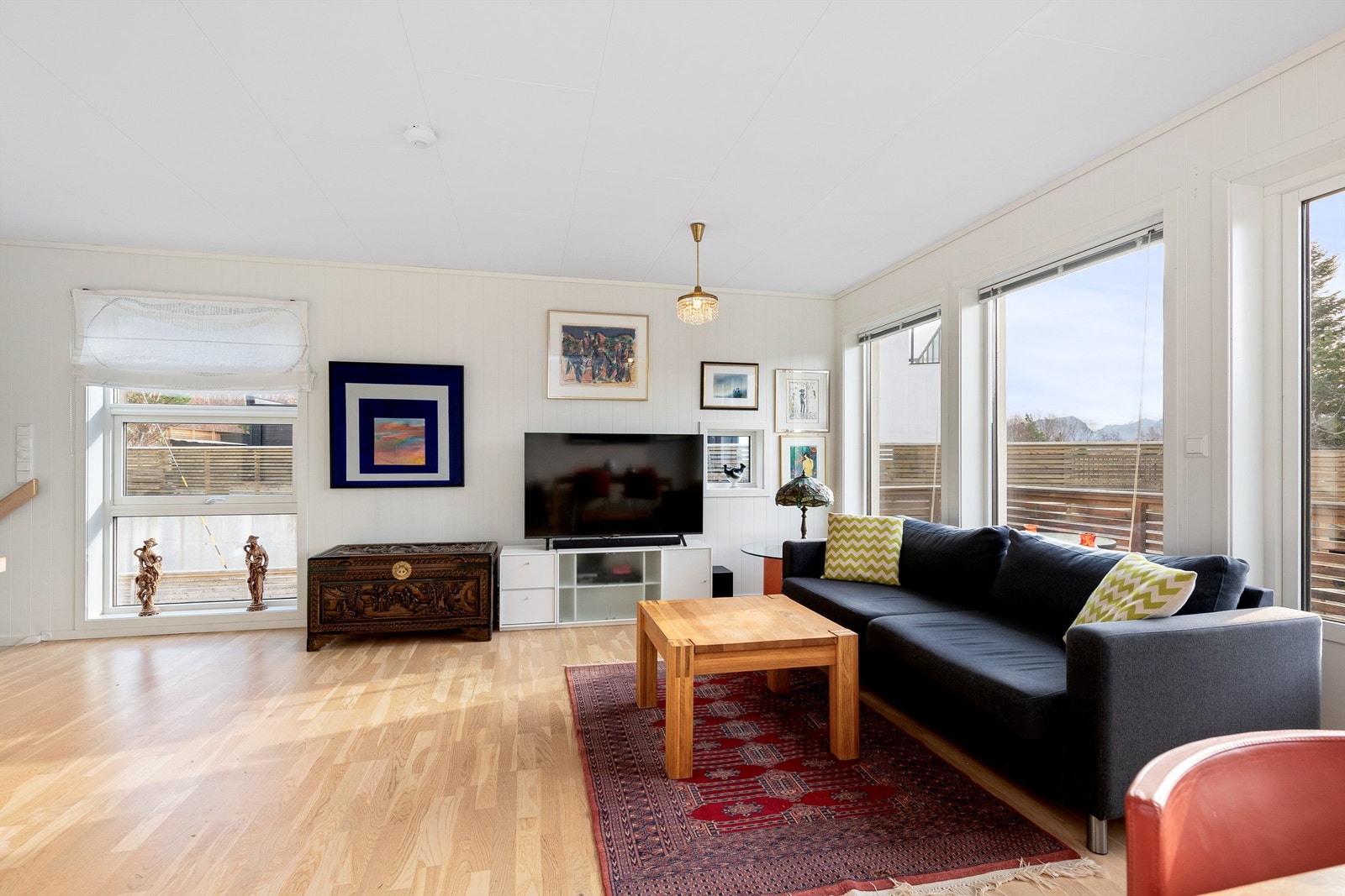 Stuen har store vindusflater som slipper inn godt med naturlig lys Galleribilde