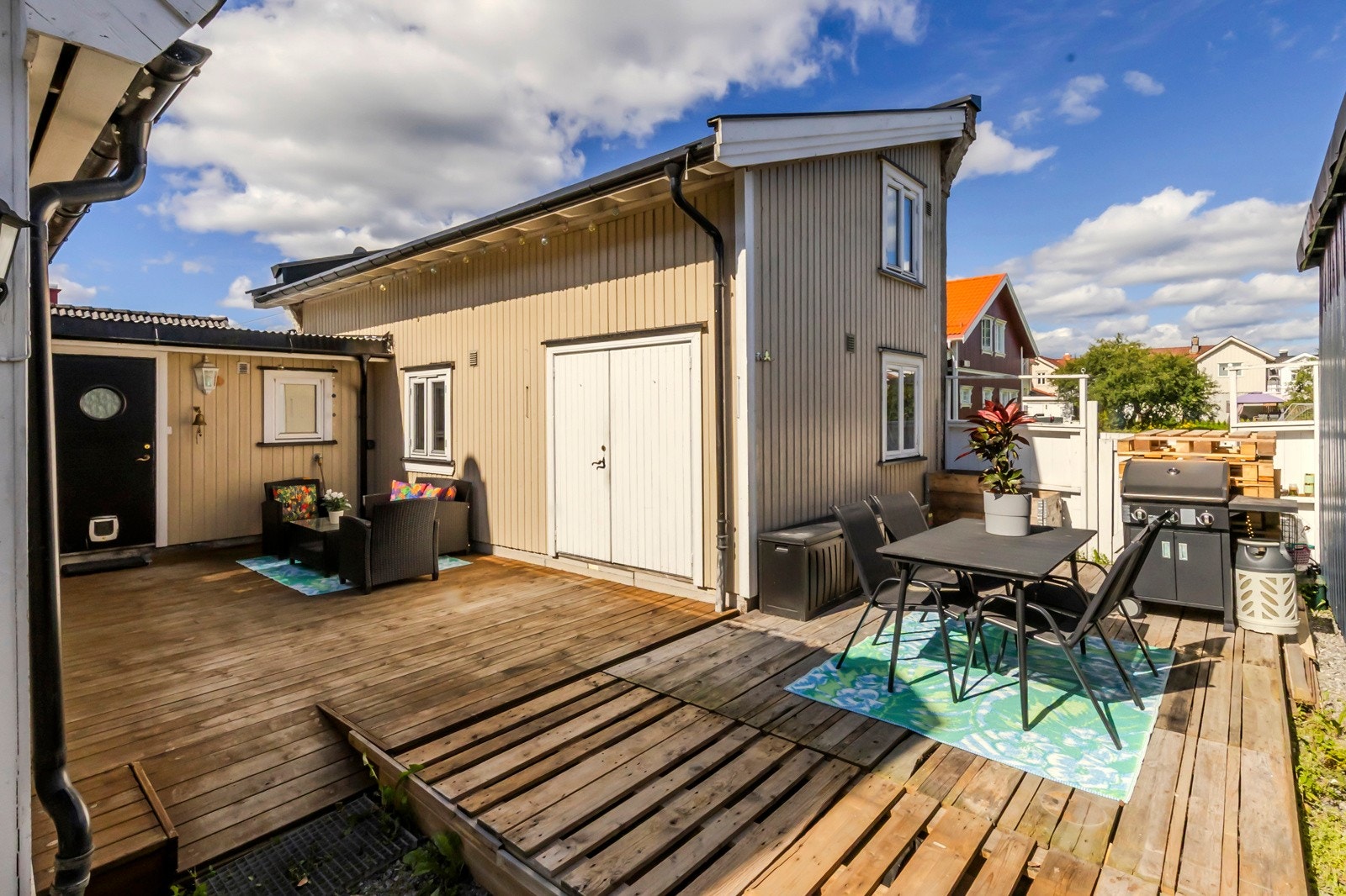 Koselig uteplass med treplatting mellom hovedhus og anneks. Galleribilde