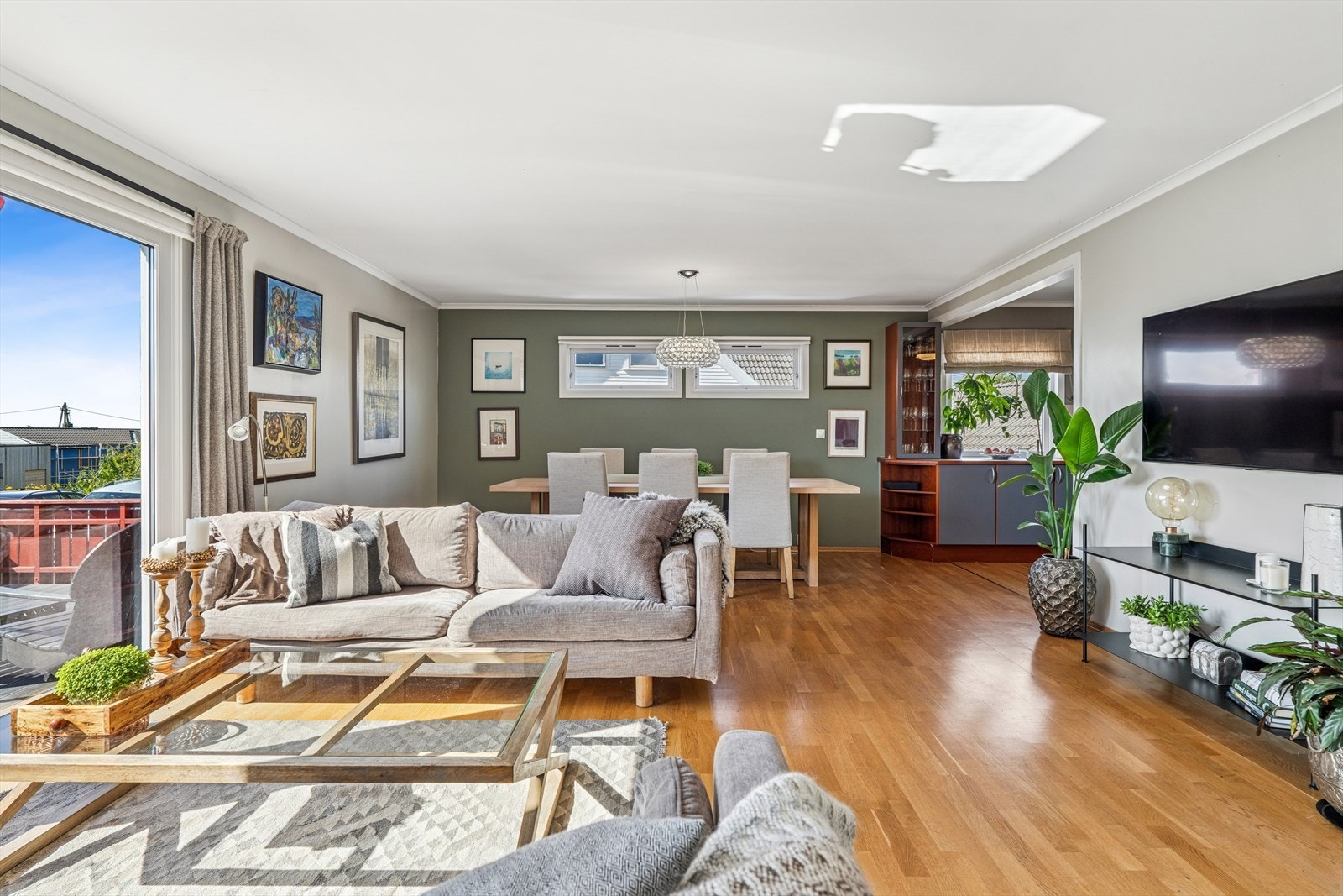 Lys og romslig stue med store vindusflater som slipper inn rikelig med naturlig lys. Perfekt for hyggelige sammenkomster. Galleribilde