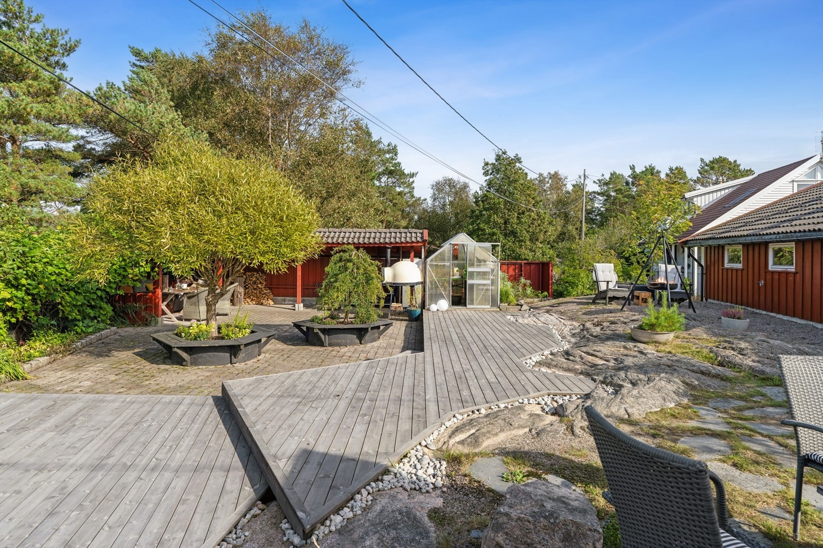Sjarmerende uteområde med moderne terrasse, drivhus og frodig hage. Perfekt for avslapning og sosiale sammenkomster i naturskjønne omgivelser. Galleribilde