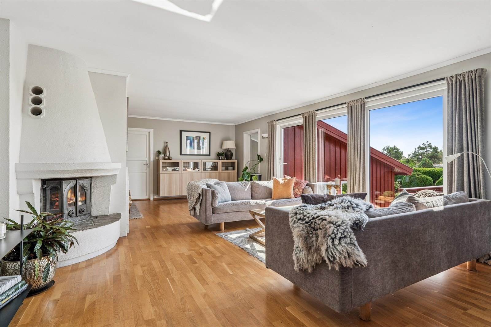 Lys og romslig stue med store vinduer som slipper inn naturlig lys. Peis gir varme og koselig atmosfære. Galleribilde