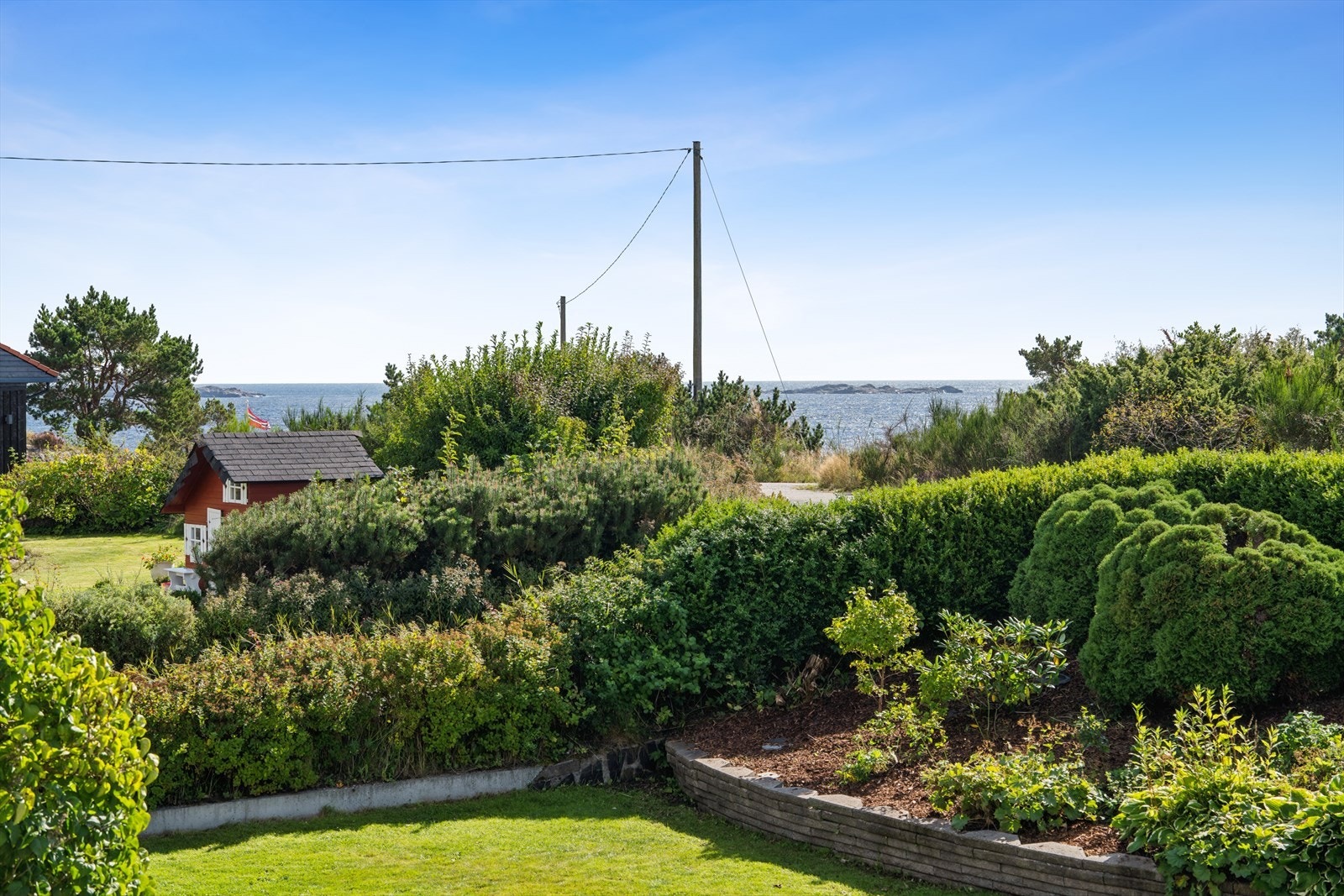 Nydelig utsikt over sjøen, frodig hage, idyllisk beliggenhet nær kysten. Perfekt for de som søker ro og naturskjønnhet. Galleribilde