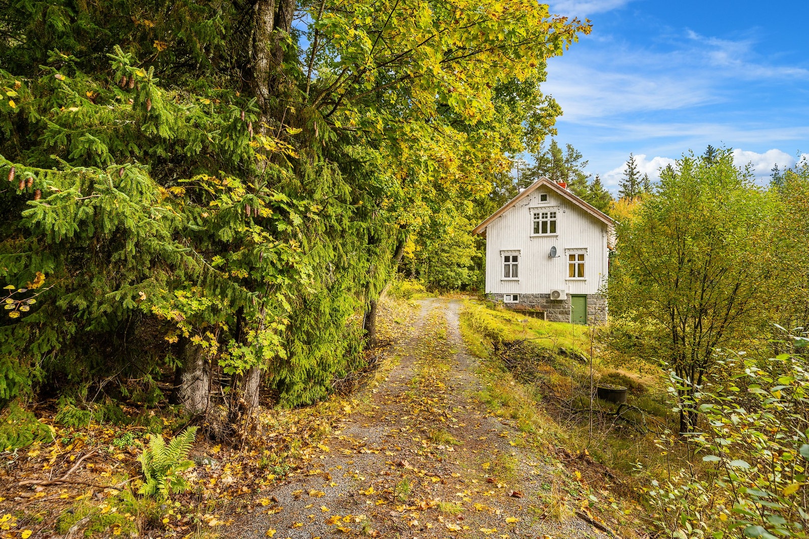 Eiendommen ligger tilbaketrukket fra hovedveien, men privat innkjørsel. Galleribilde