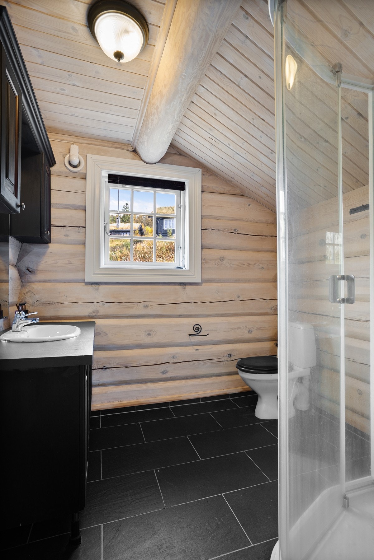 Baderom i 2.etasje. Flislagt gulv, dusjkabinett, toalett og innredning med servant Galleribilde