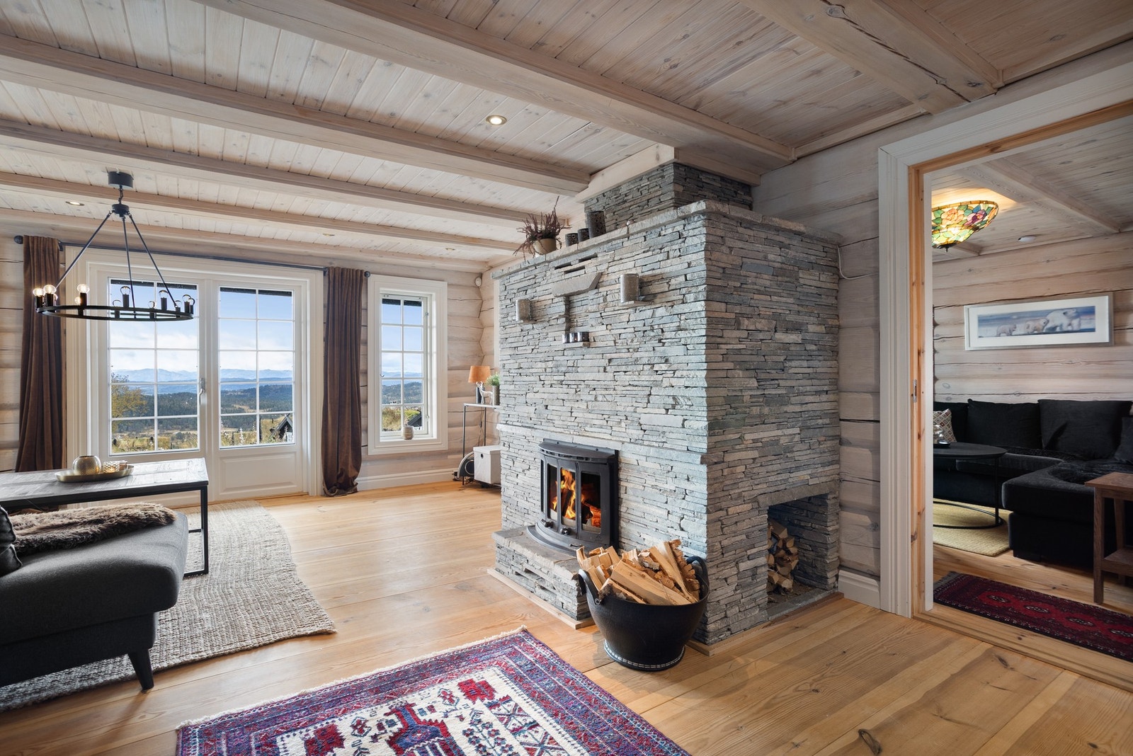 Utgang til terrasse fra stue. Store vindusflater slipper lyset og utsikten inn i sofakroken Galleribilde