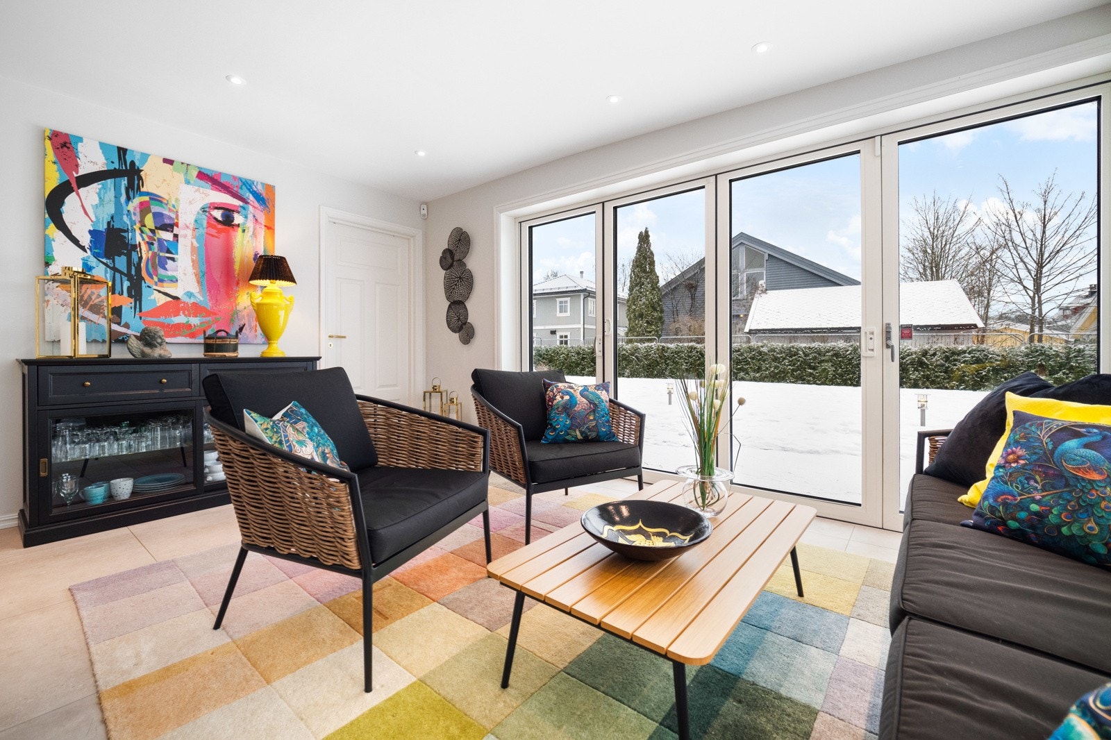 De høye vinduene og dørene bader rommet i dagslys og visker ut skillet mellom ute og inne. Galleribilde