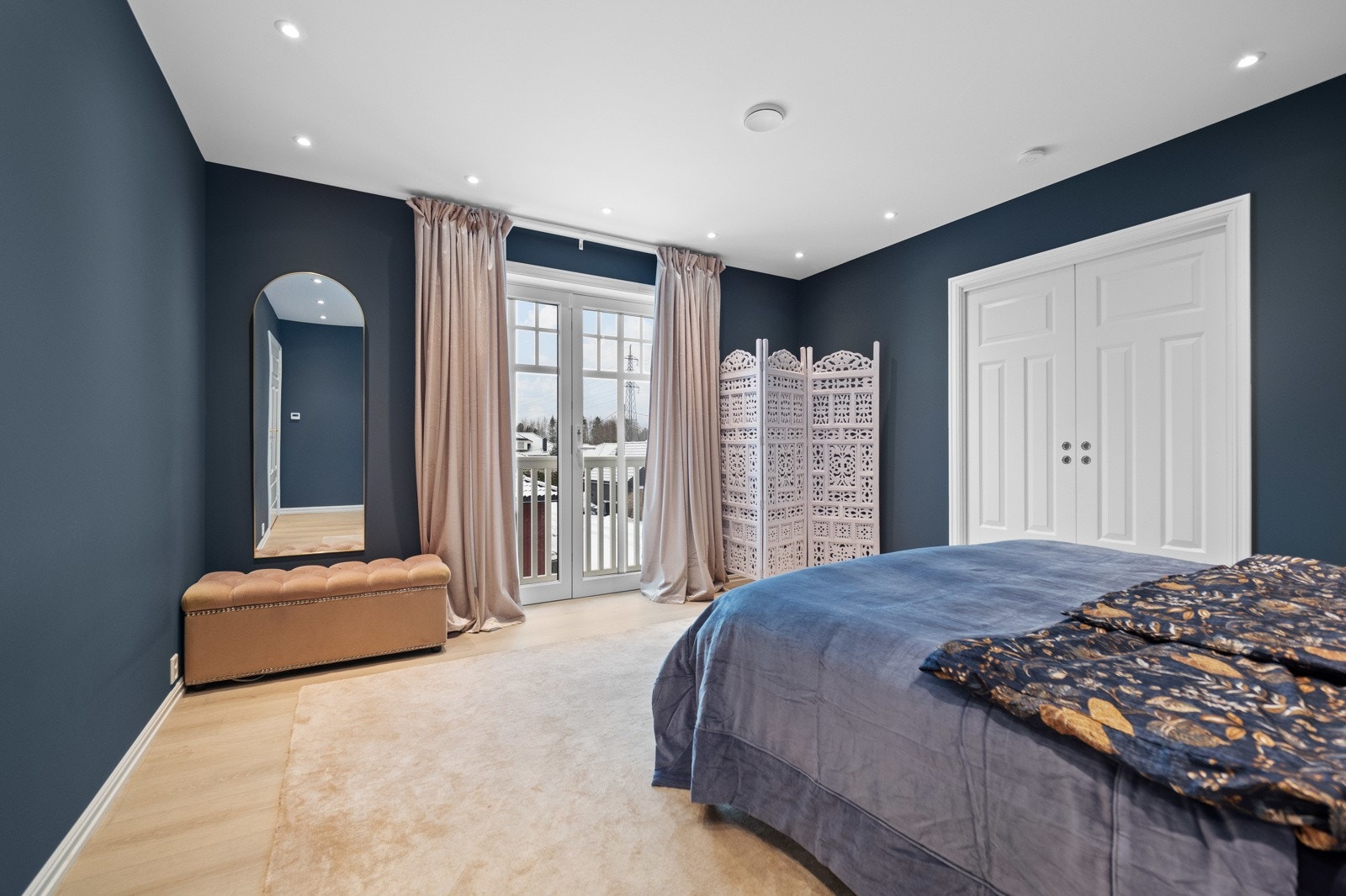 Mastersoverommet er malt i en støvete blåtone og har downlights, fransk balkong og doble skyvedører til omkledningsrom. Galleribilde