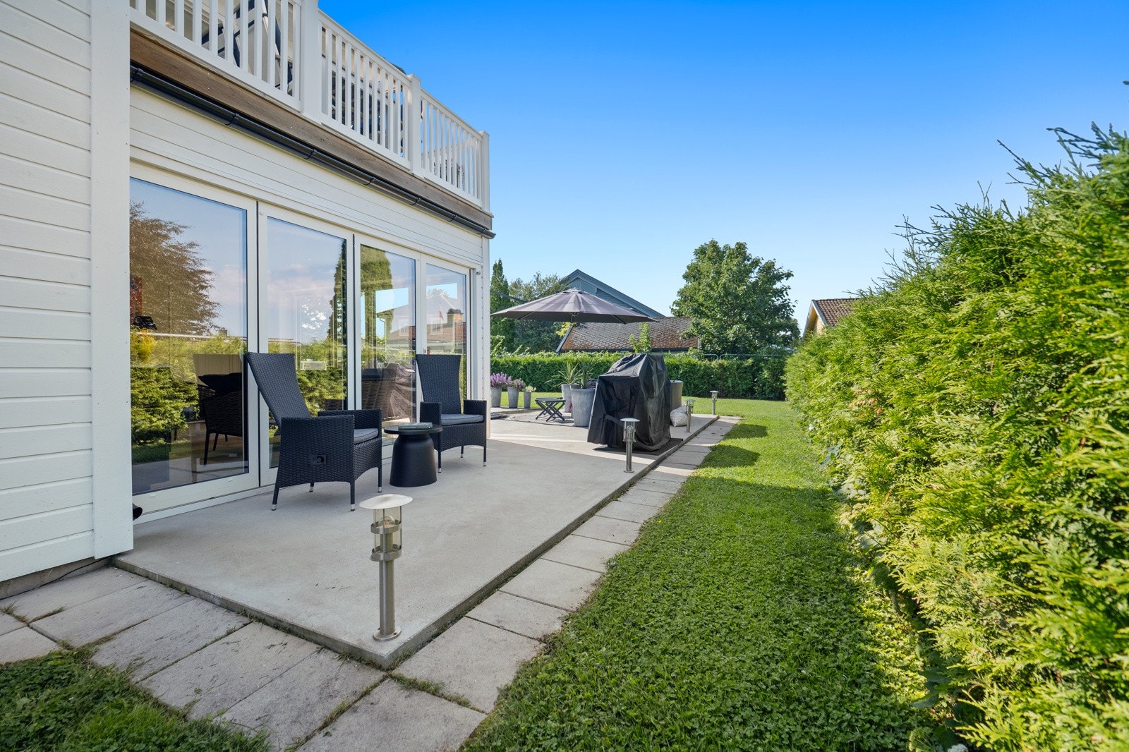 Boligen omkranses av asfaltert gårdsplass og en sydvestvendt hage med støpt markterrasse på ca. 62 kvm. Galleribilde