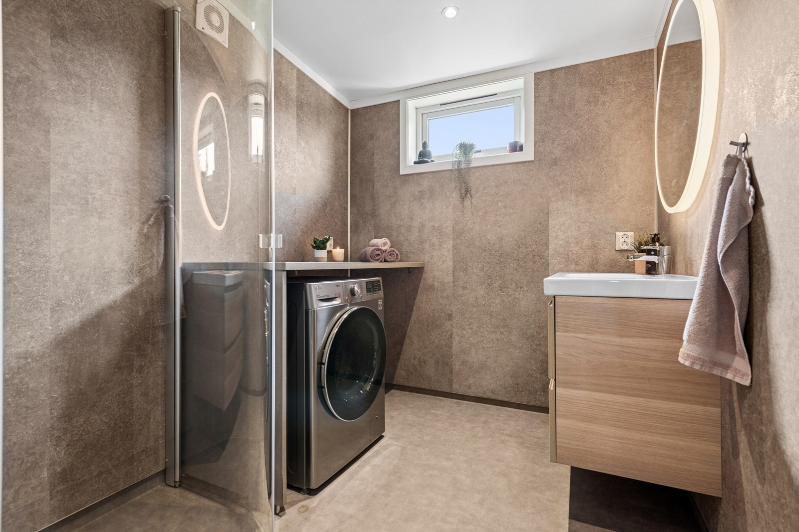 Badet er utstyrt med toalett, dusjhjørne, baderomsinnredning og plass med opplegg til vaskemaskin. Galleribilde