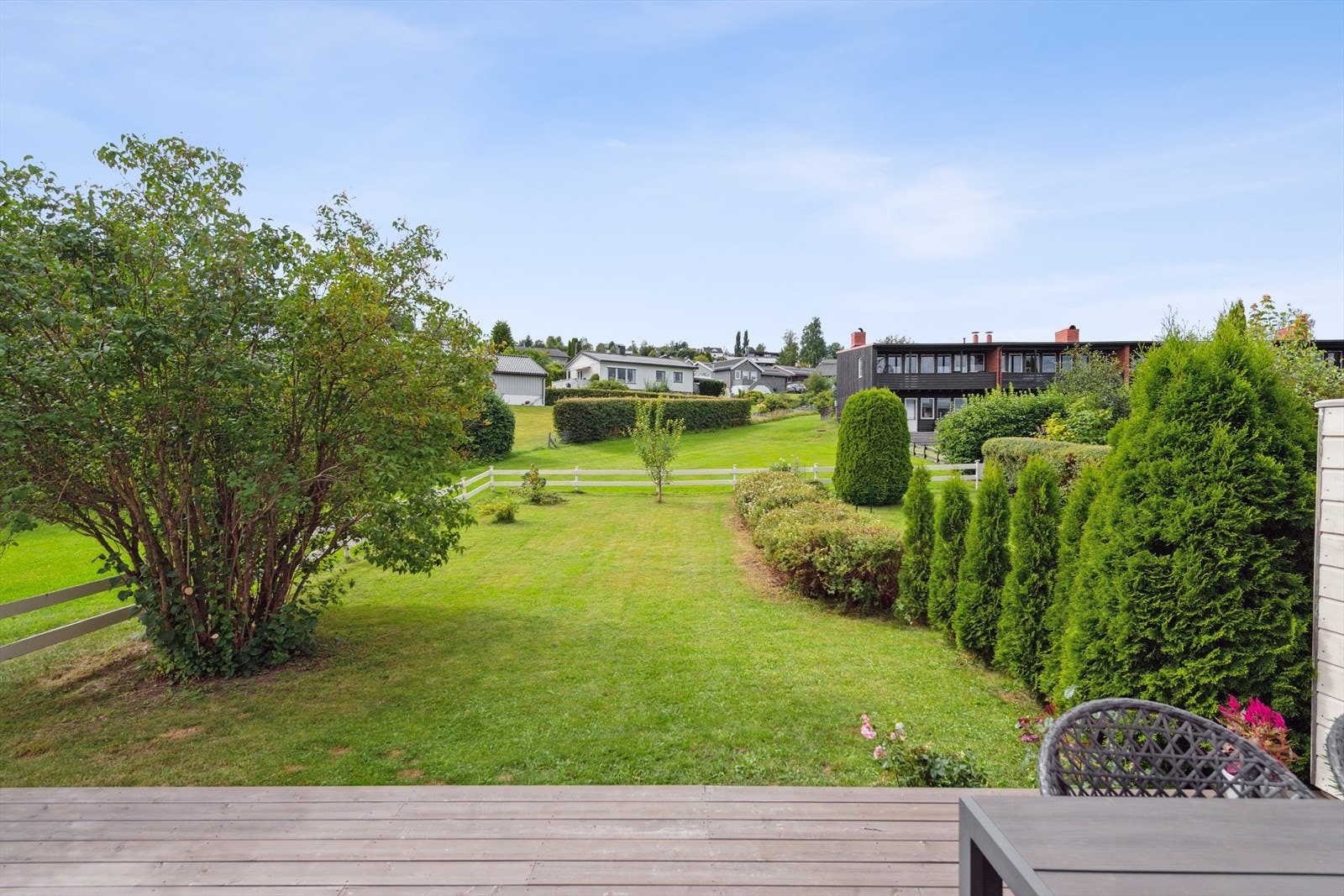 En pen og lettstelt hage med plen og noe beplantninger. Galleribilde