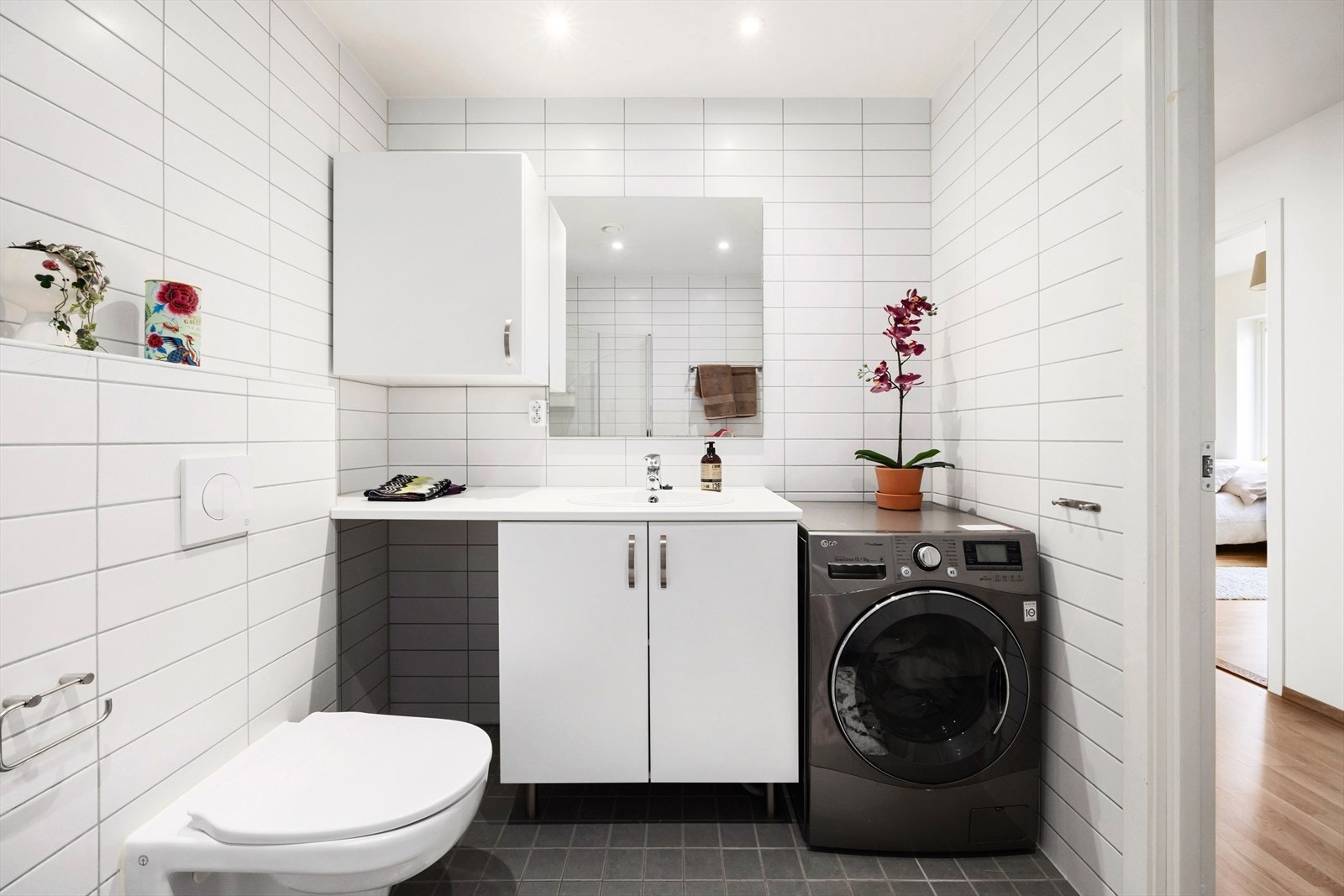 Baderomsinnredningen består av servantskap, dusjsone, toalett og opplegg for vaskemaskin og tørketrommel. Det er tilkoblet mekanisk avtrekk Galleribilde