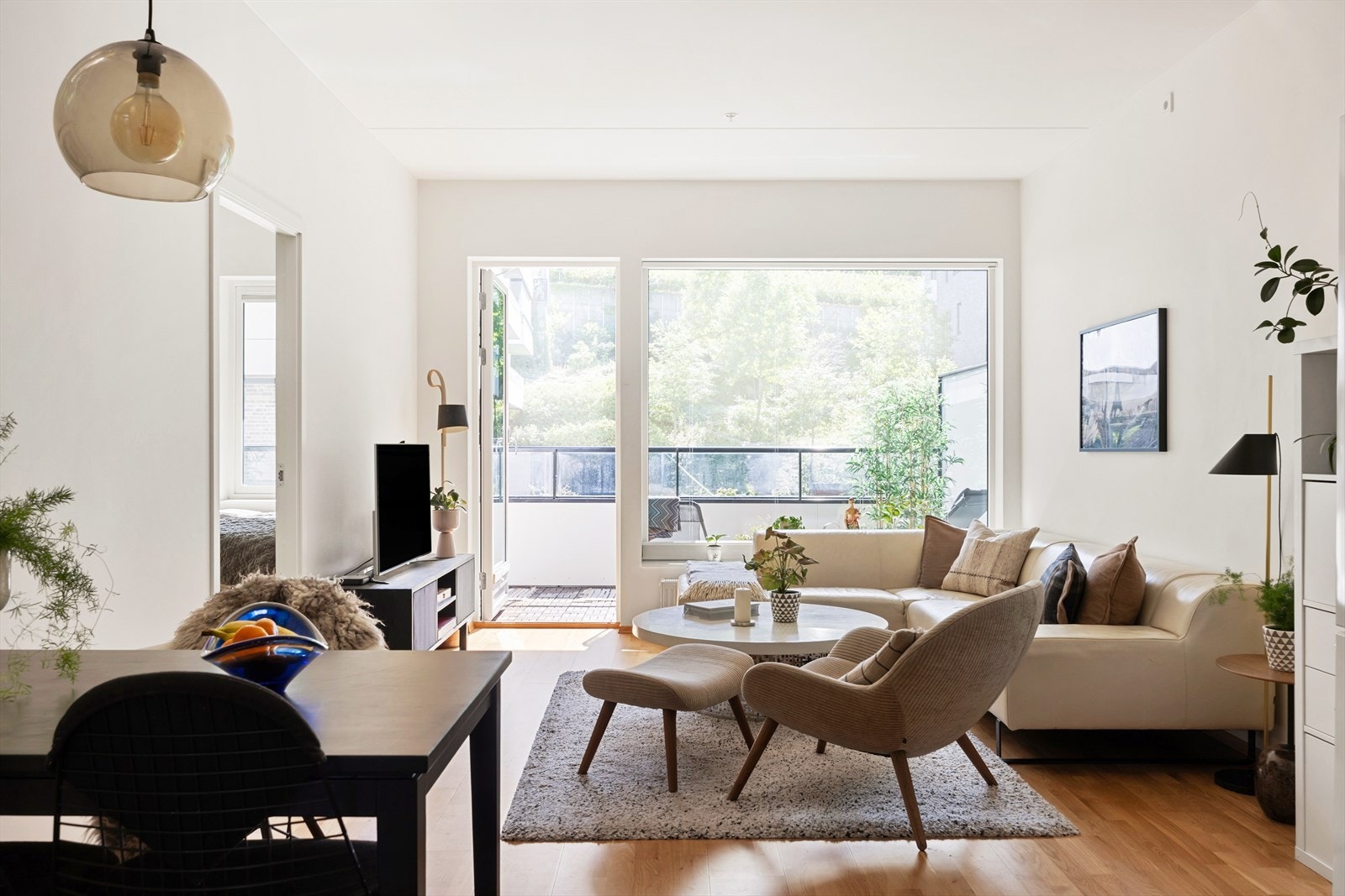 Lys stue med store vinduer som slipper inn rikelig med lys, som bidrar til en luftig romfølelse Galleribilde