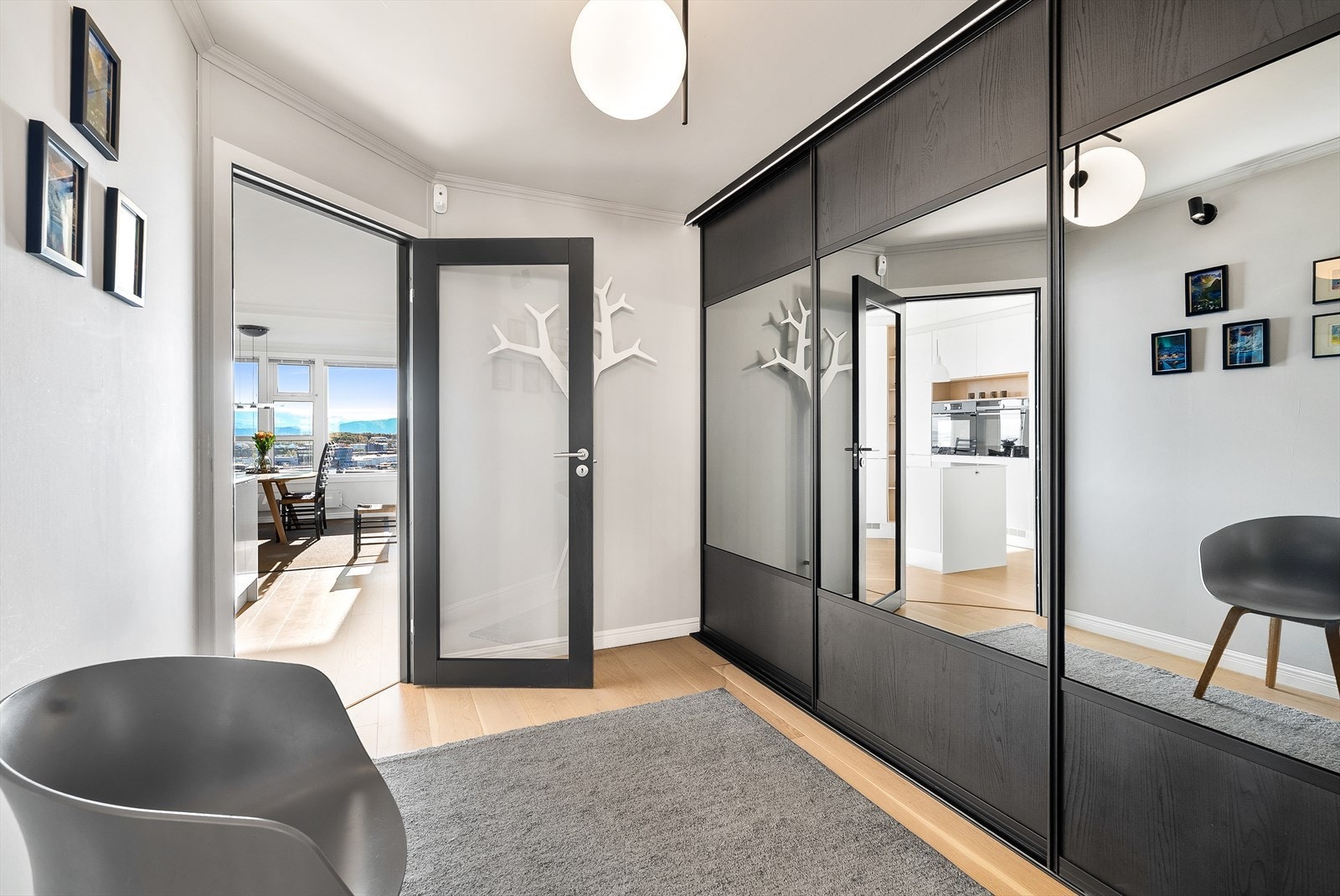 Entréen gir et flott førsteinntrykk, med stor skyvedørsgarderobe fra Langlo og glassdør inn mot stue og kjøkken. Her kan du skimte utsikten fra det øyeblikket du kommer inn. Galleribilde