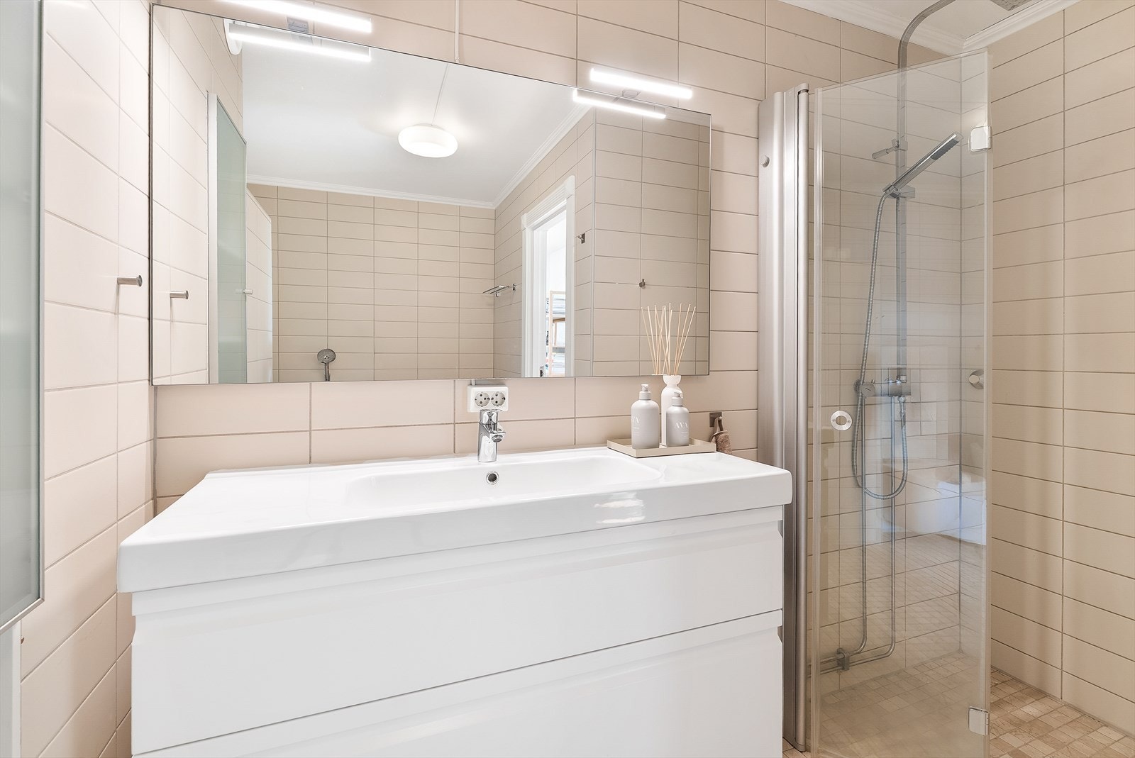 Baderommet har delikate fliser fra topp til tå, dusjnisje med glassdører, ny innredning og nytt badekar, samt vegghengt toalett. Galleribilde