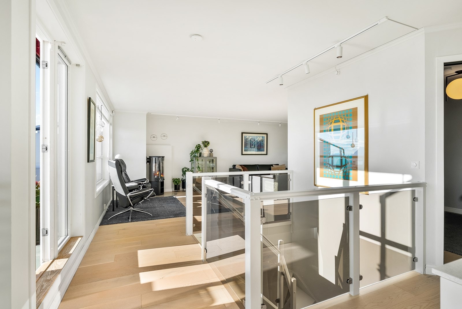 Trappen er et smykke i seg selv - med flott rekkverk av sotet glass som leder ned til underetasjen. Galleribilde