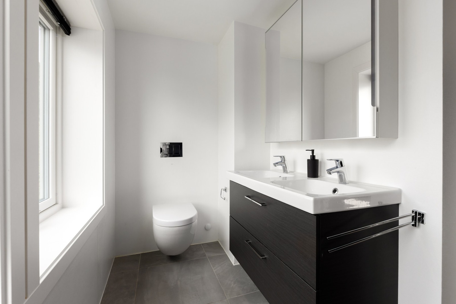 Bad nummer to har flislagt gulv, doble servanter og vegghengt toalett. Begge badene er fra 2017 Galleribilde