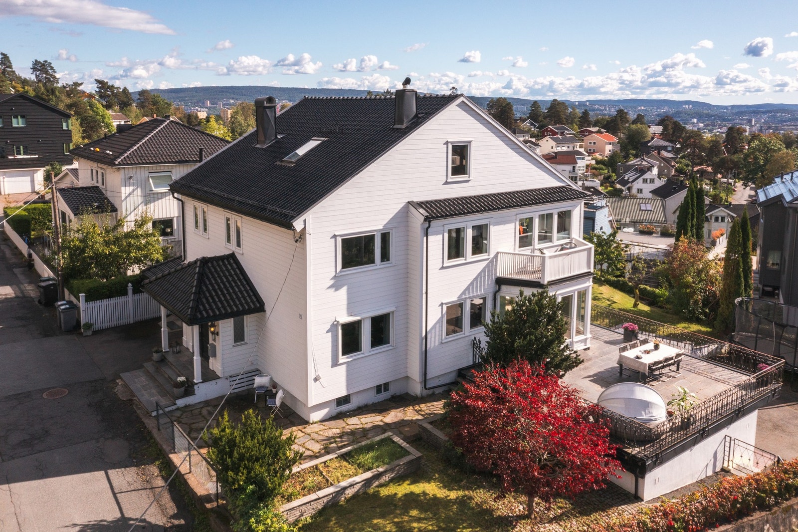 Eiendommen ligger høyt og fritt, med gjennomtenkte uteplasser som følger solen gjennom dagen.