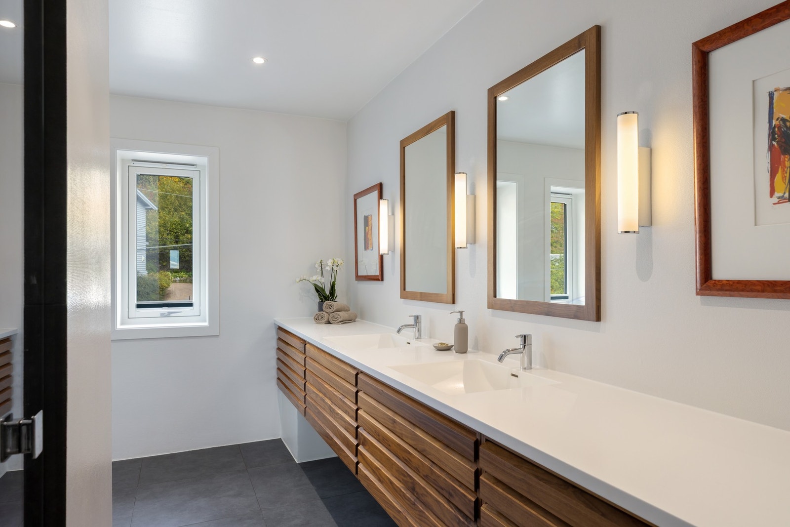 Bad med inngang fra omkledningsrom. Uno form i innredning med Corian servanter og skittentøysjakt direkte til vaskerom i kjelleren