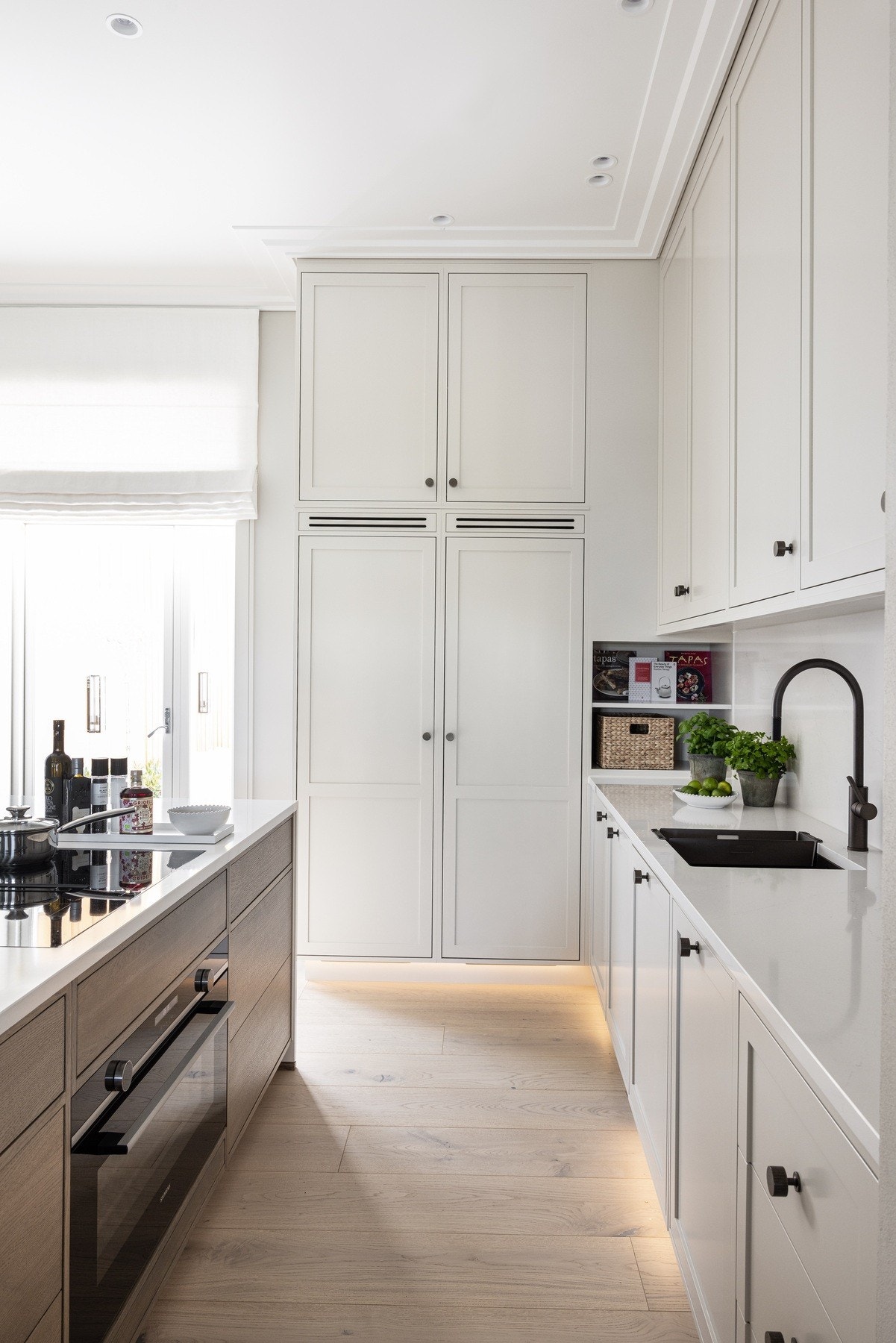 Rikelig skapplass med integrert kjøl, frys, stekeovn og 90 cm platetopp. Vitrineskap med hyller i diamantglass og håndtak i bronse gir et elegant og eksklusivt uttrykk. Galleribilde