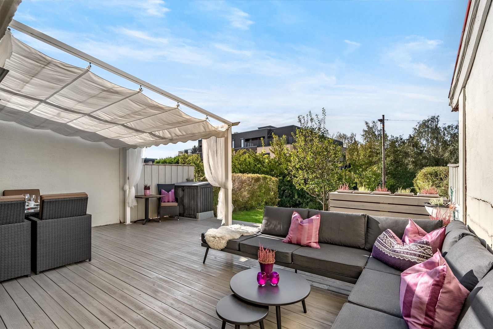 Fra stuen har du utgang til markterrasse i trekonstruksjoner, med beiset terrassebord og levegger på siden. Galleribilde