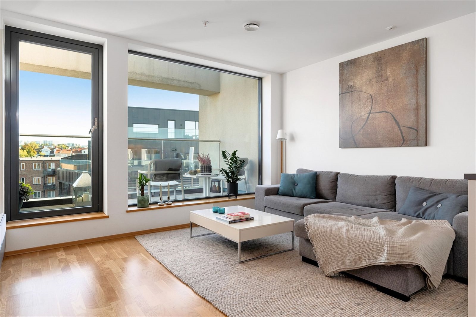 Romslig oppholdsrom med eikeparkett, store vindusflater og direkte utgang til solrik balkong med god byutsikt. Galleribilde