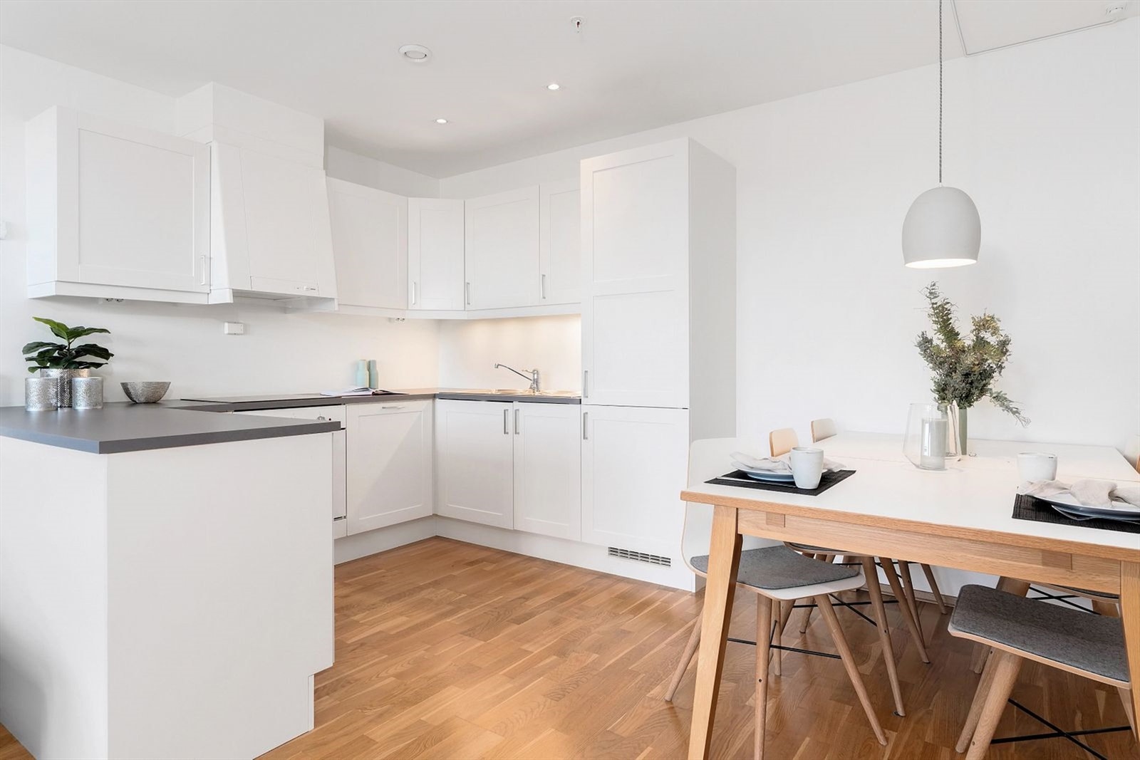 Stilrent hvitt kjøkken med mørk benkeplate, samt gode oppbevaringsmuligheter. Galleribilde