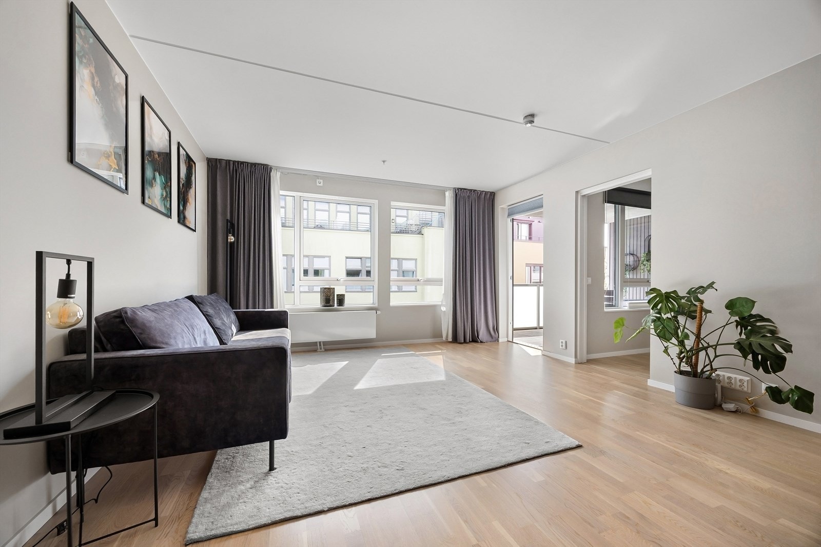 Store vindusflater gir rikelig med naturlig lys. Hotellfølelse i stuen med dobble gardiner fra tak til gulv. Galleribilde