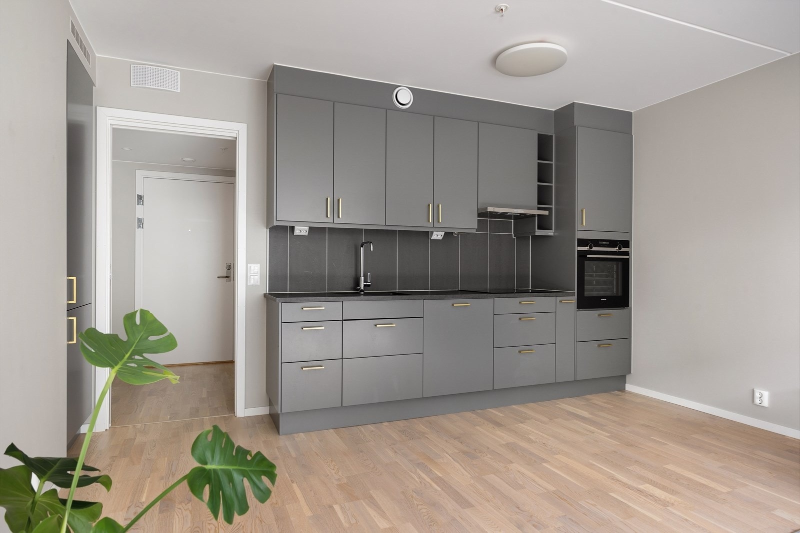 Lekkert Marbodal kjøkkeninnredning, utsyrt med komfyr, oppvaskmaskin, platetopp og avtrekksvifte. Innebygd kjøl/frys i nisje til venstre. Galleribilde