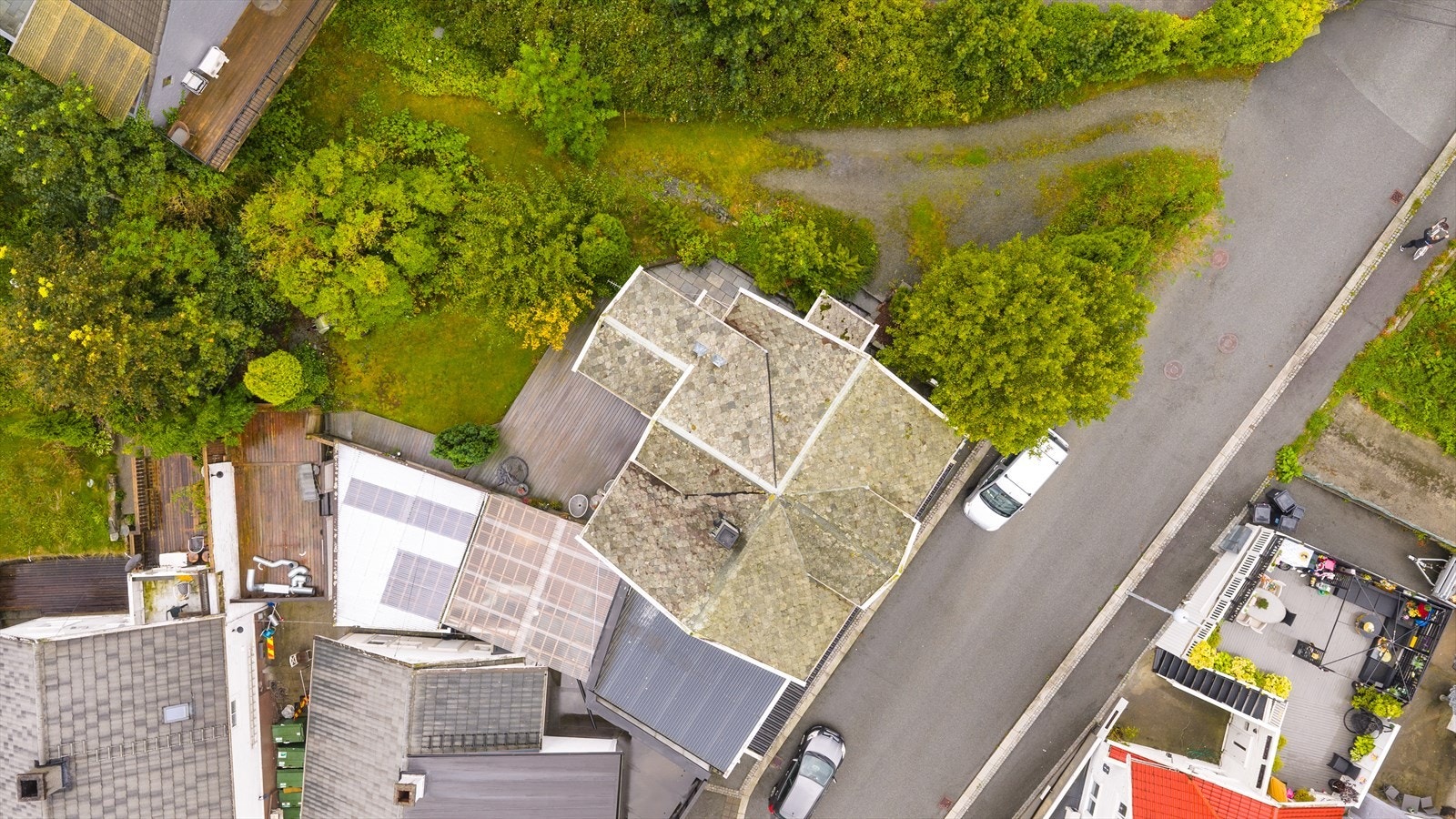 Tomten er opparbeidet med gruset gårdplass, steinheller ved inngangsparti, terrasse og hage med diverse beplantning Galleribilde