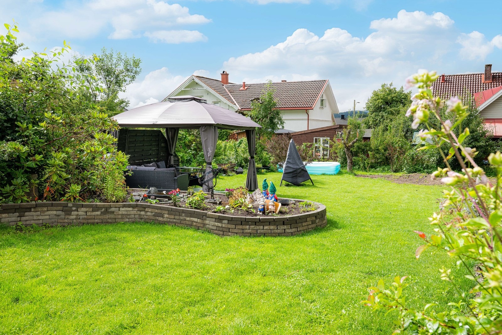 Eiendommen fremstår i dag som en svært barnevennlig og idyllisk tomt med god plass til lek, aktivitet og flere fine oppholdssoner. Galleribilde
