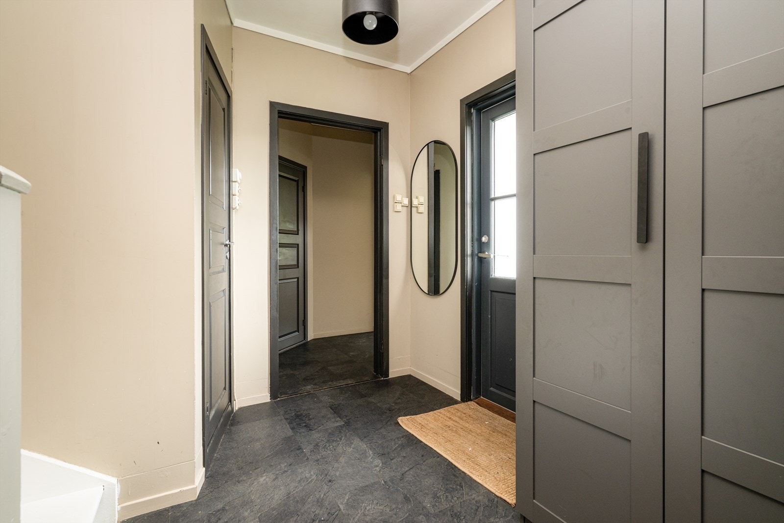 En lys og hyggelig entré ønsker velkommen inn hvor det er fin plass til oppbevaringsmøbler for sko og yttertøy. Videre kommer du inn i en liten gang i lik utførelse hvor det er adkomst til soverom og kjøkken/stue. Galleribilde