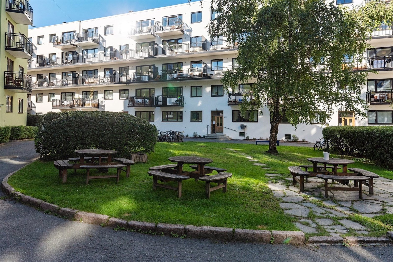 Bakgården er pent opparbeidet med sittegrupper, bed og belagt med heller/asfalt Galleribilde