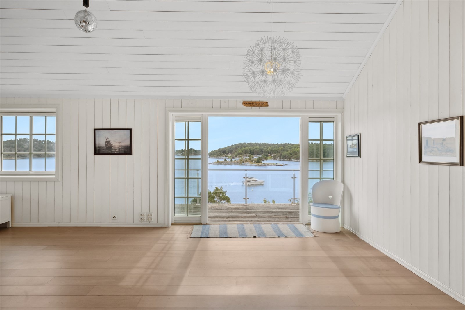 Store vindusflater slipper inn rikelig med dagslys og gir en luftig atmosfære, mens dobbel dør leder ut til en balkong med panoramautsikt over innseilingen til Lillesand sentrum. Galleribilde
