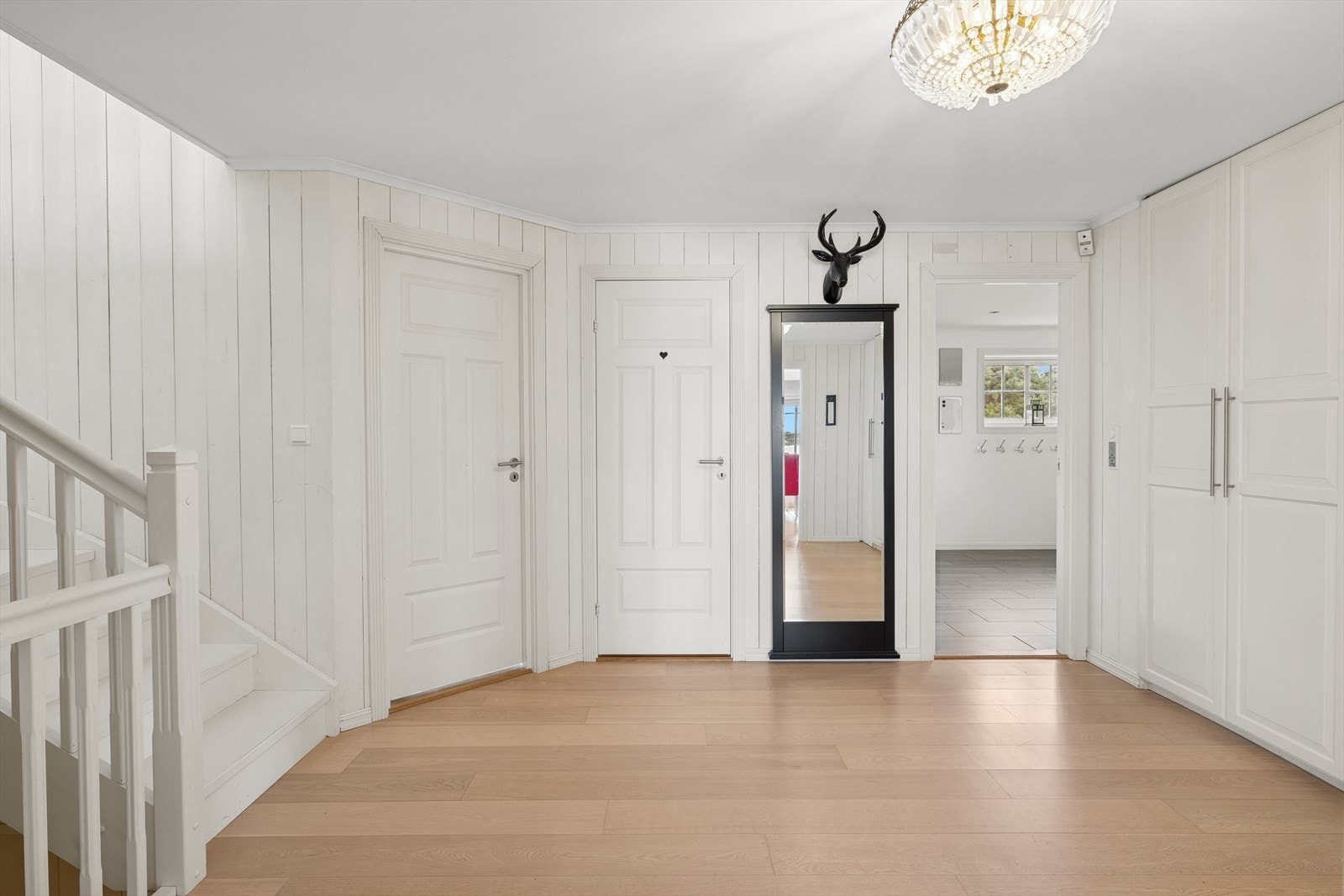 Hallen fungerer som et naturlig knutepunkt i hjemmet, med tilgang til flere av boligens sentrale rom. Galleribilde