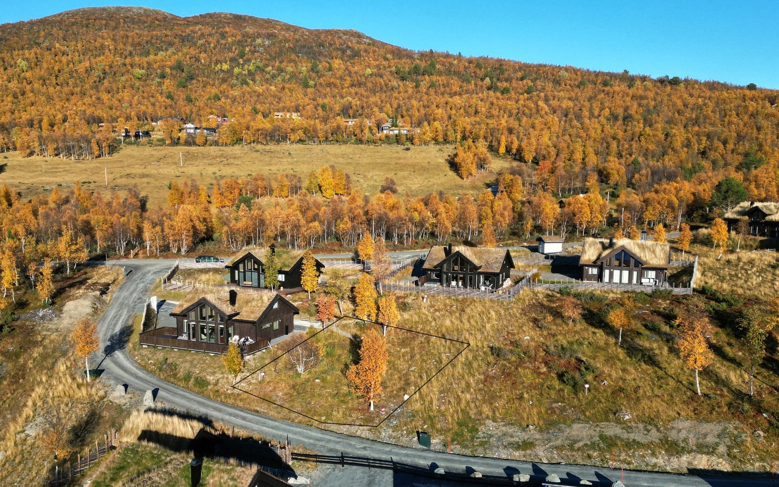 Veien på nedsiden gir tomta høyde slik at hyttene foran ikke tar utsikt og sol. Galleribilde