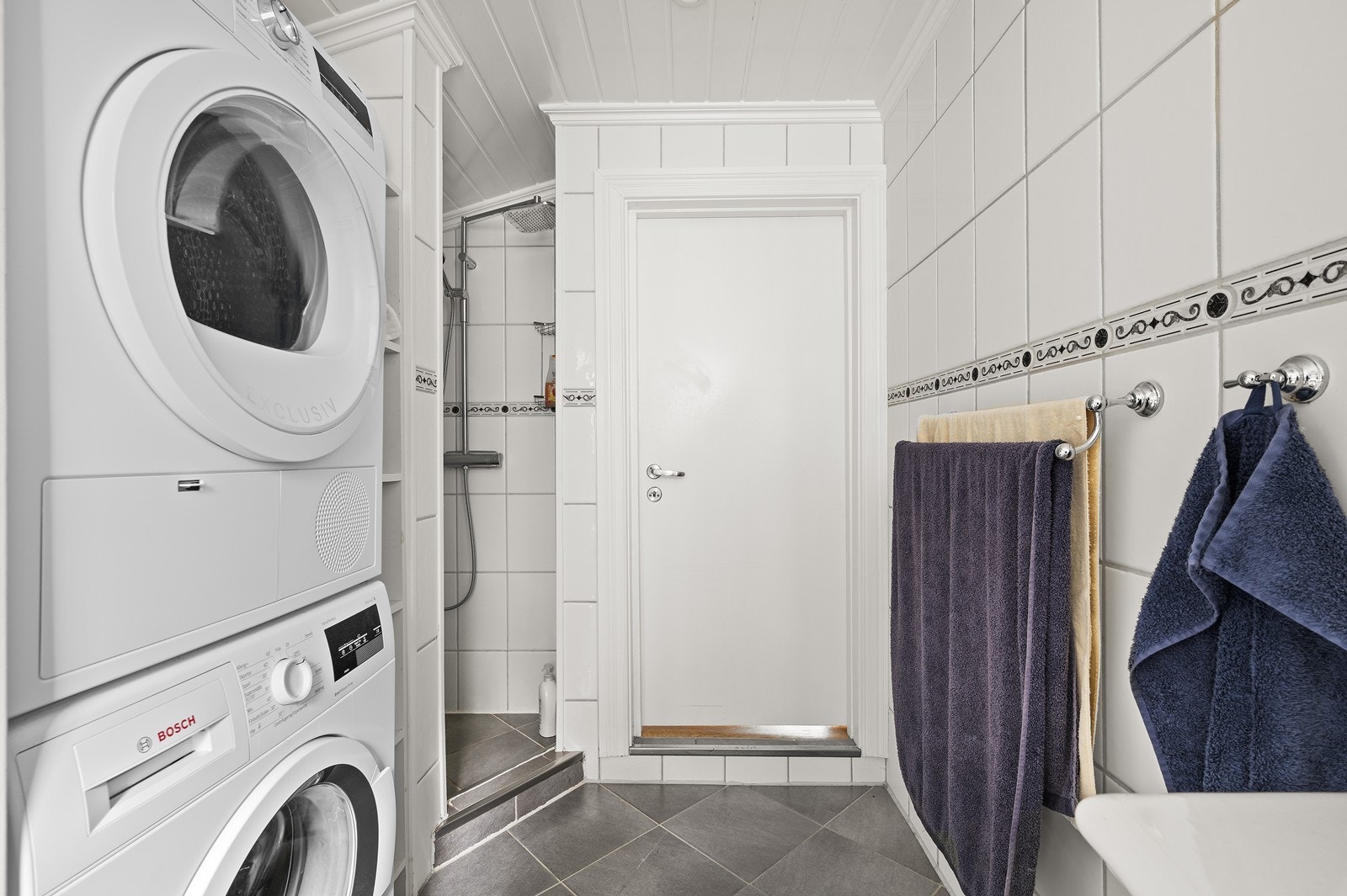 Bad med wc, dusjhørne, håndvask med skuffer, skap og speil. Galleribilde