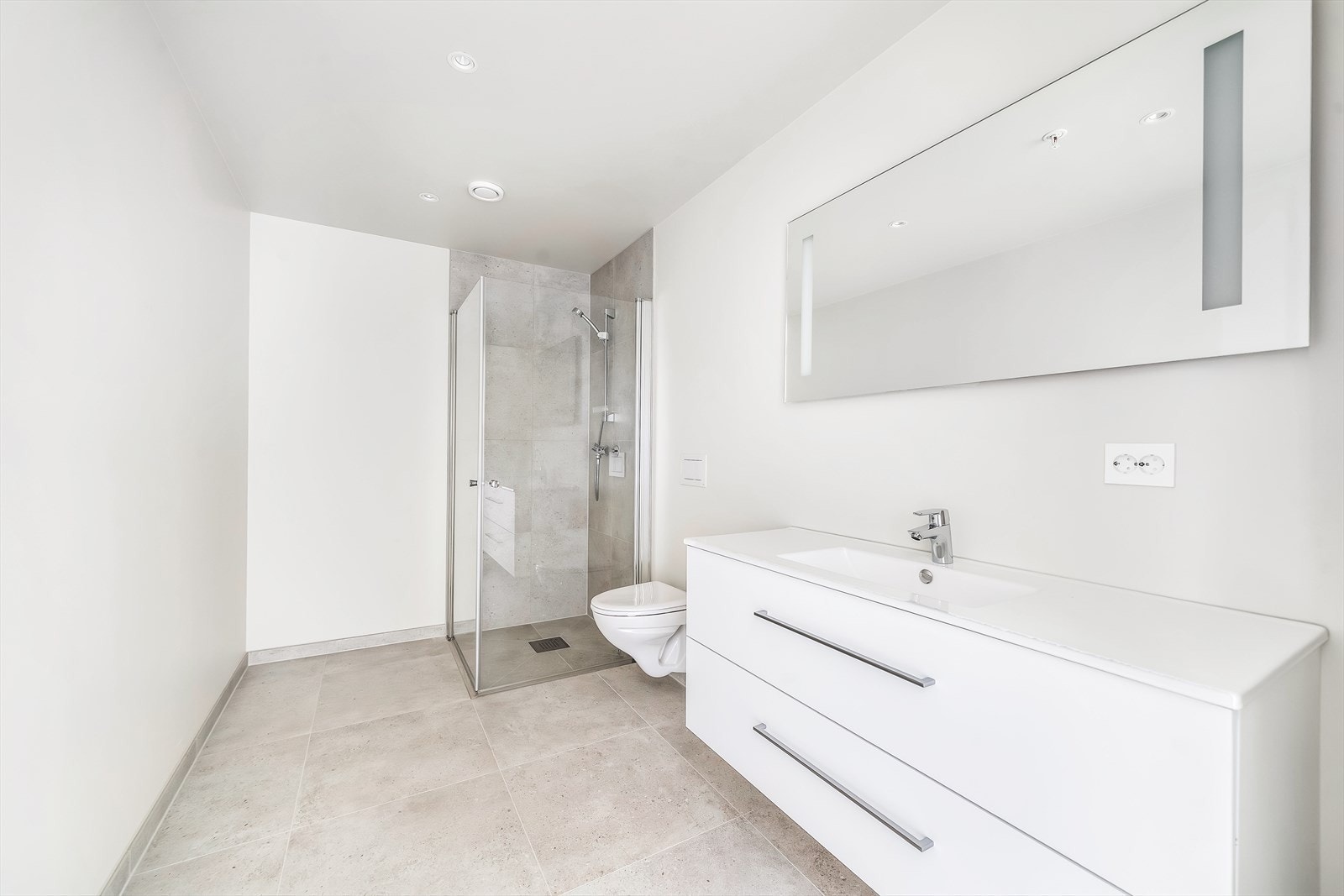 Bad med fliser på gulv og lys innredning. Galleribilde