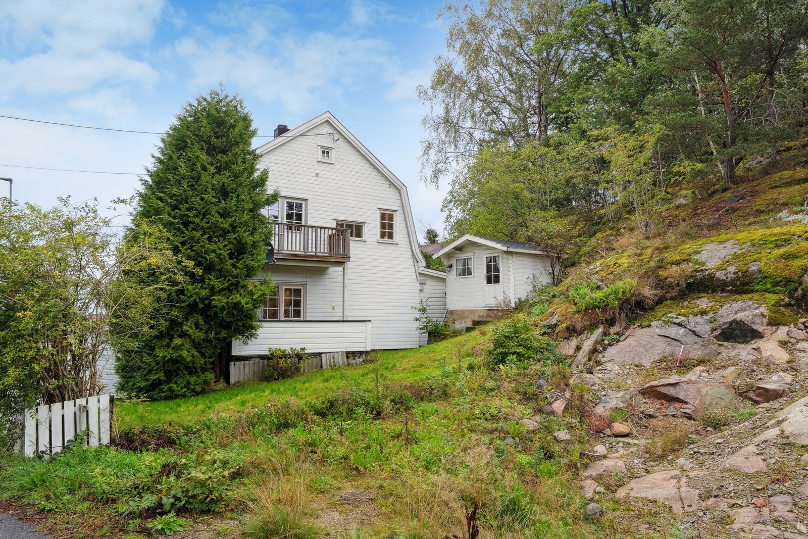 Tomten er skrånende med plen på sydsiden av tomten. Galleribilde