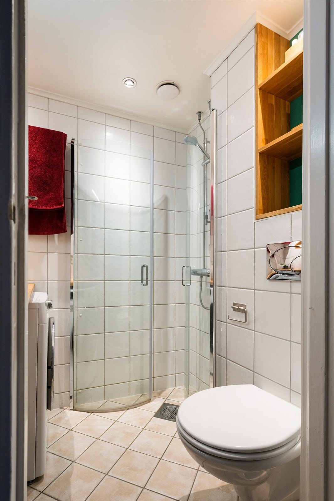 Himlingen er senket og malt, med innfelte downlights. Innredningen består av heltre benkeplate med nedfelt servant, speilskap, vegghengt toalett, dusjhjørne med svingbare glassdører og opplegg for vaskemaskin. Galleribilde