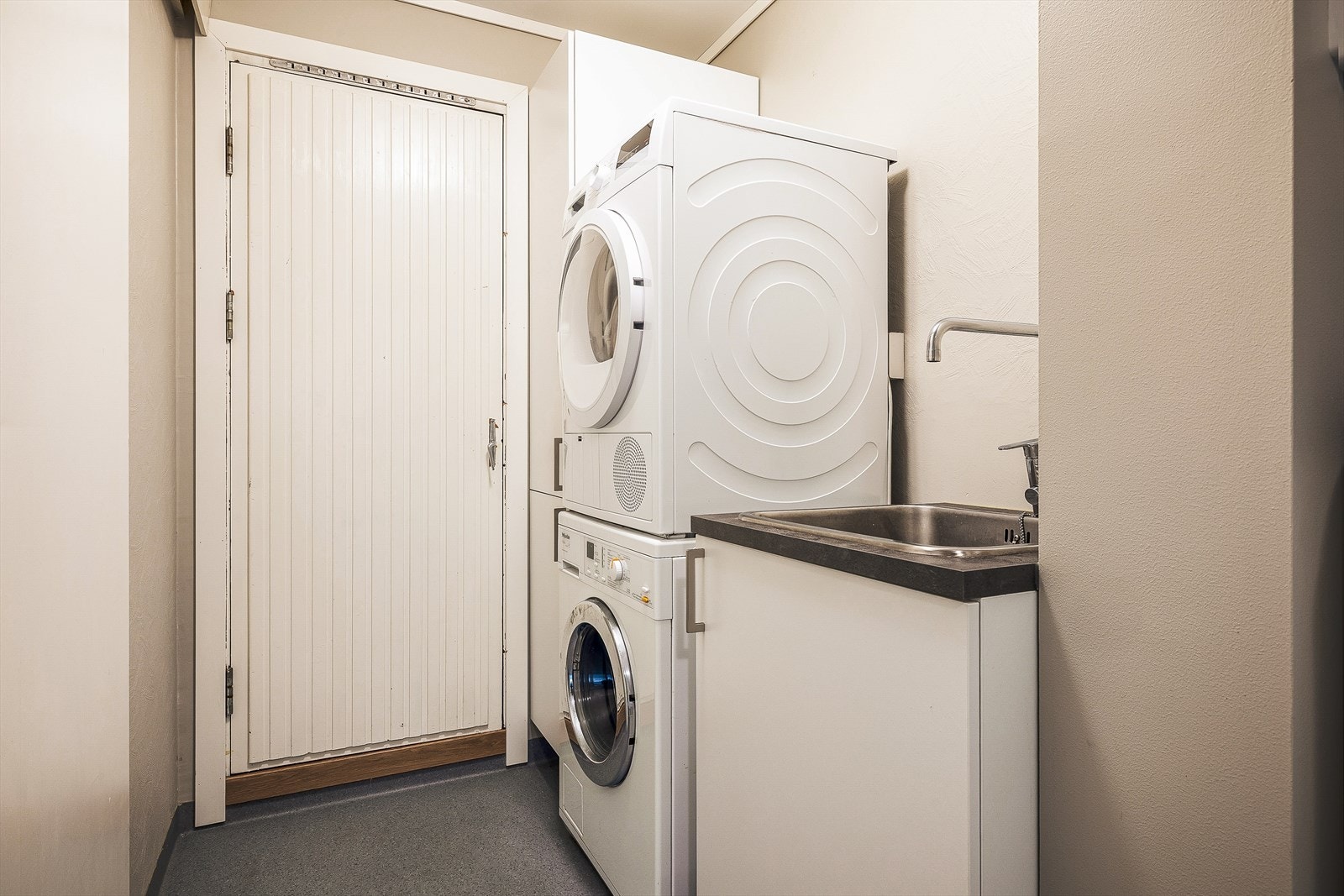 Vaskerommet er innredet med nedfelt servant og opplegg for vaskemaskin. Galleribilde