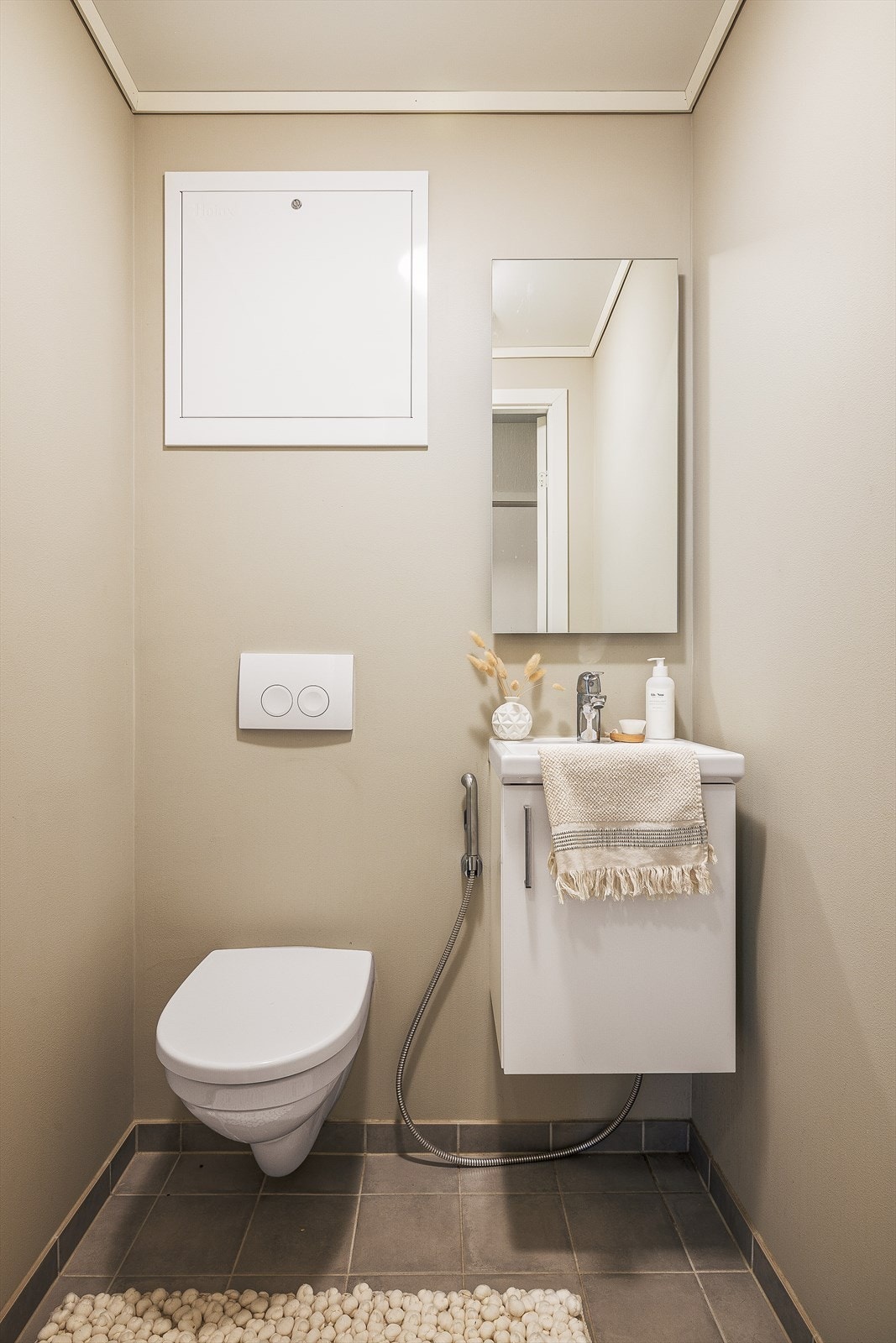 Toalettrommet inneholder vegghengt toalett og servant med skap. Galleribilde