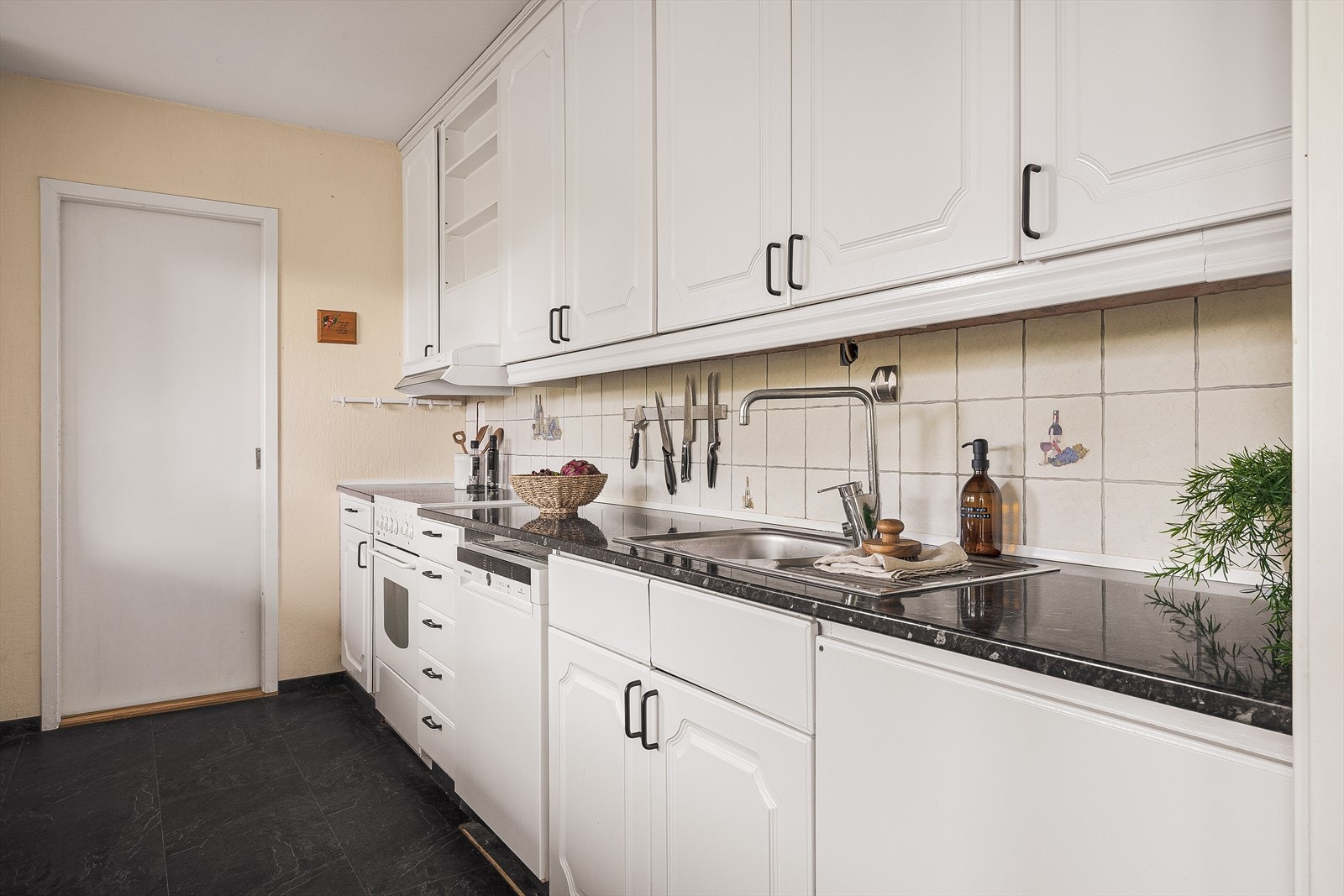 Kjøkkeninnredningen består av hvite glatte fronter og benkeplate av laminat. Galleribilde