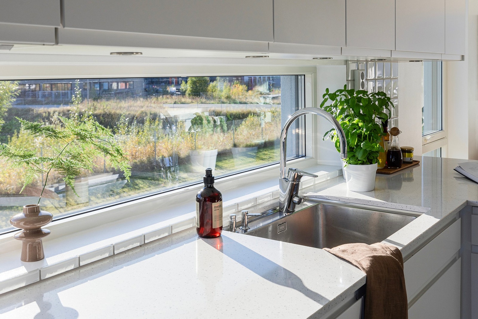 God arbeidslys på kjøkken - både naturlig fra endevindu og rikelig med spotter under overskap. Galleribilde