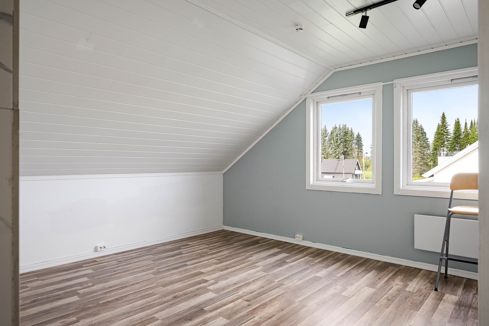 Lys og hyggelig stue med laminat på gulv, overflater malt i lyse farger og to store vinduer som slipper inn fint lys. Galleribilde